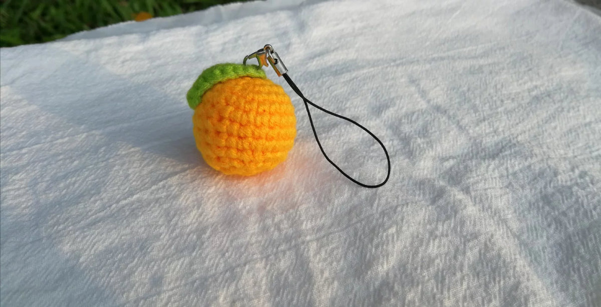 Virkad mandarin-nyckelring med grönt blad