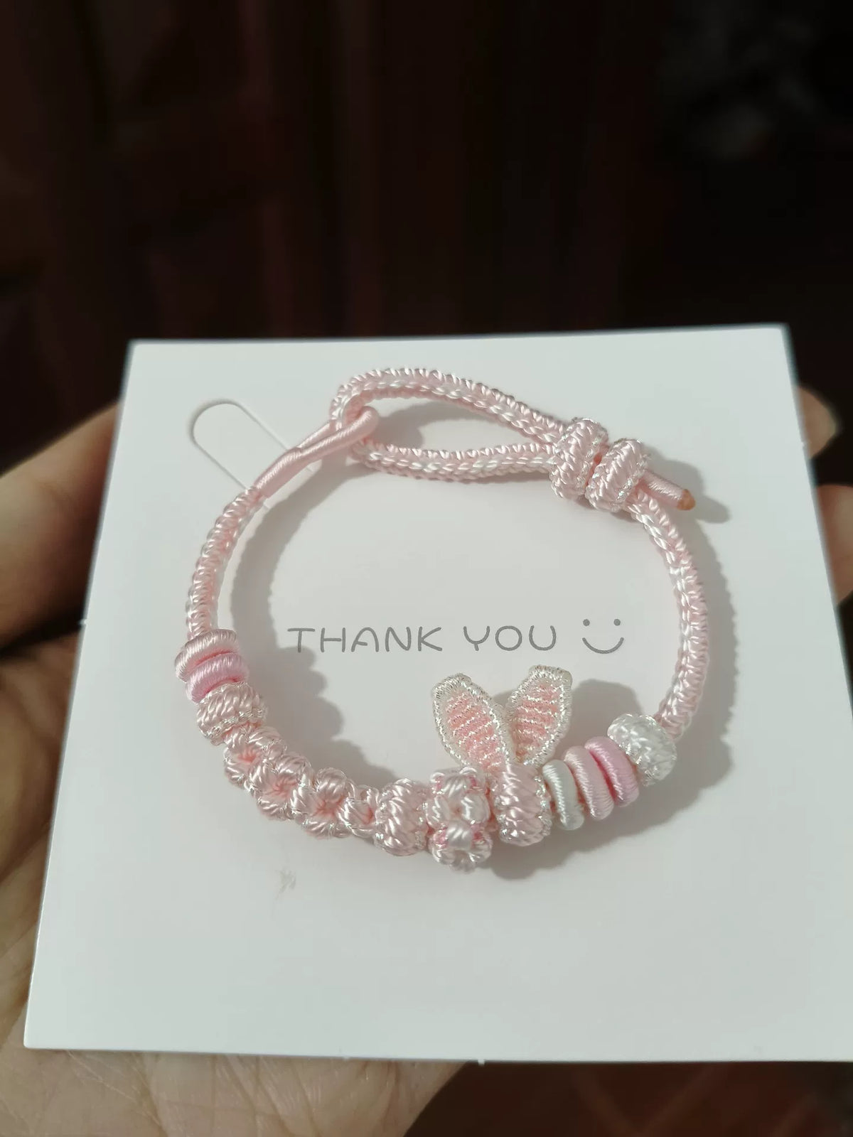 Handgema roze gevlochten armband met konijnenostjes