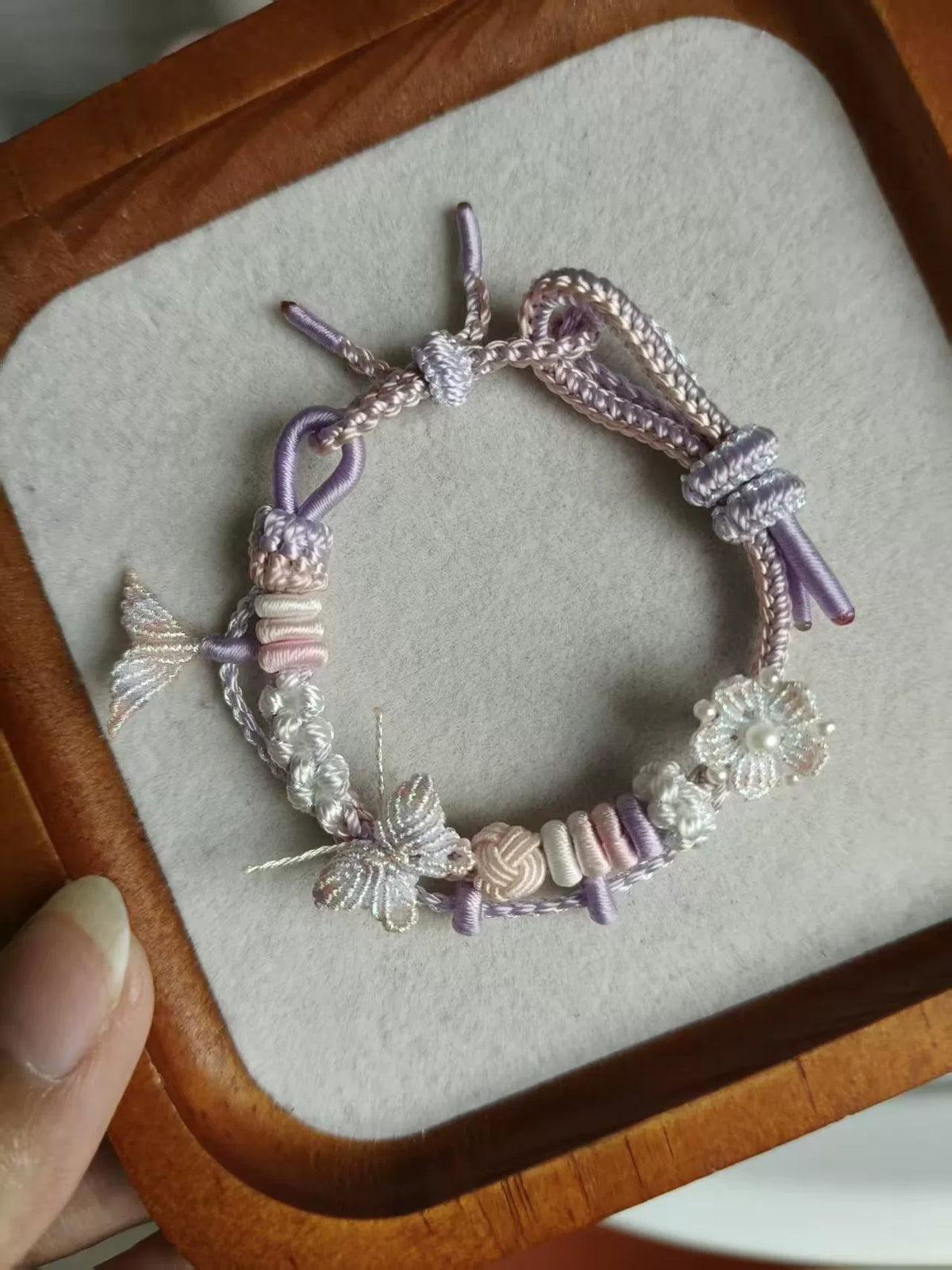 Pulseira tecida à mão com gradiente rosa e branco e charms de borboleta