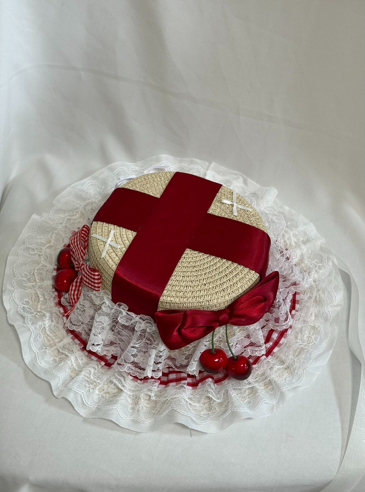 Strohoed met brede rand en rood satijn lint