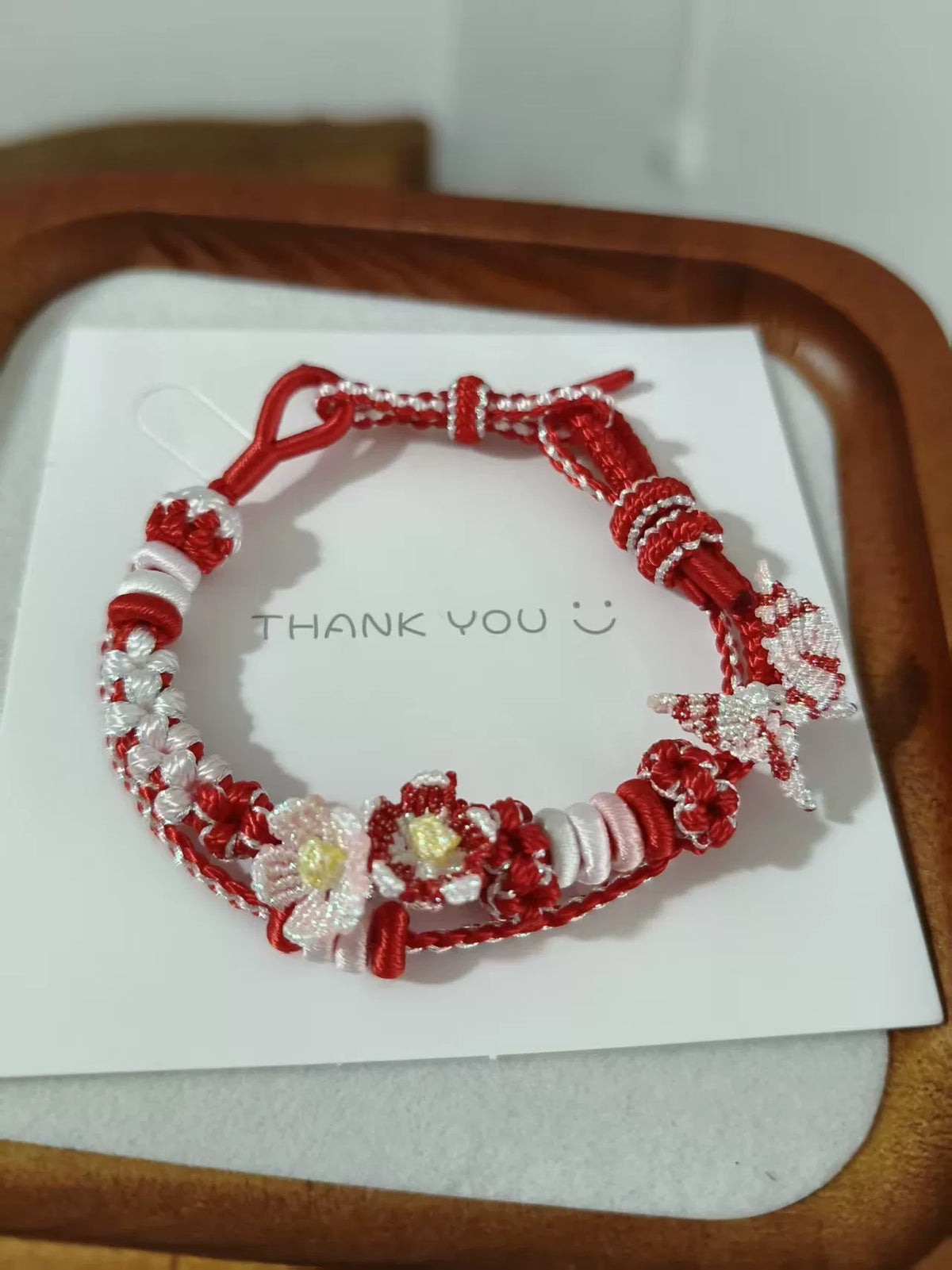 Handgegewobtes rot-weißes Armband mit Blumen
