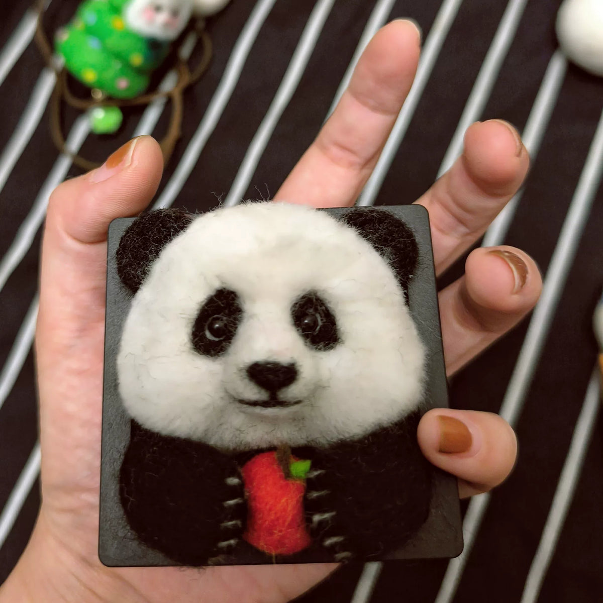 Handgjord ramdekor med panda i ullfilt som äter äpple