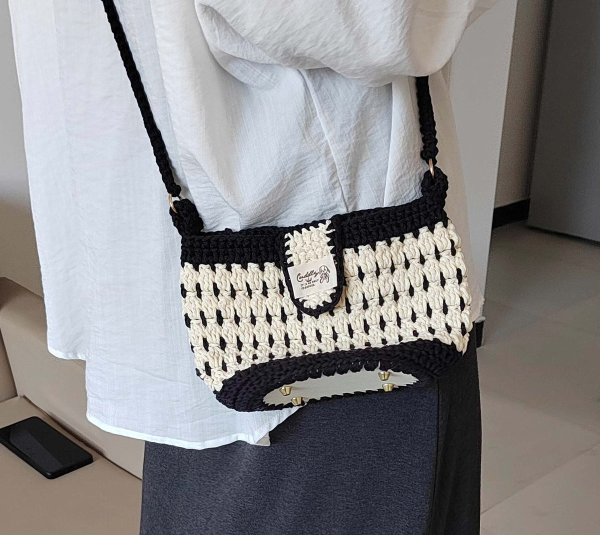 Borsa a spalla nera e bianca lavorata all'uncinetto a mano
