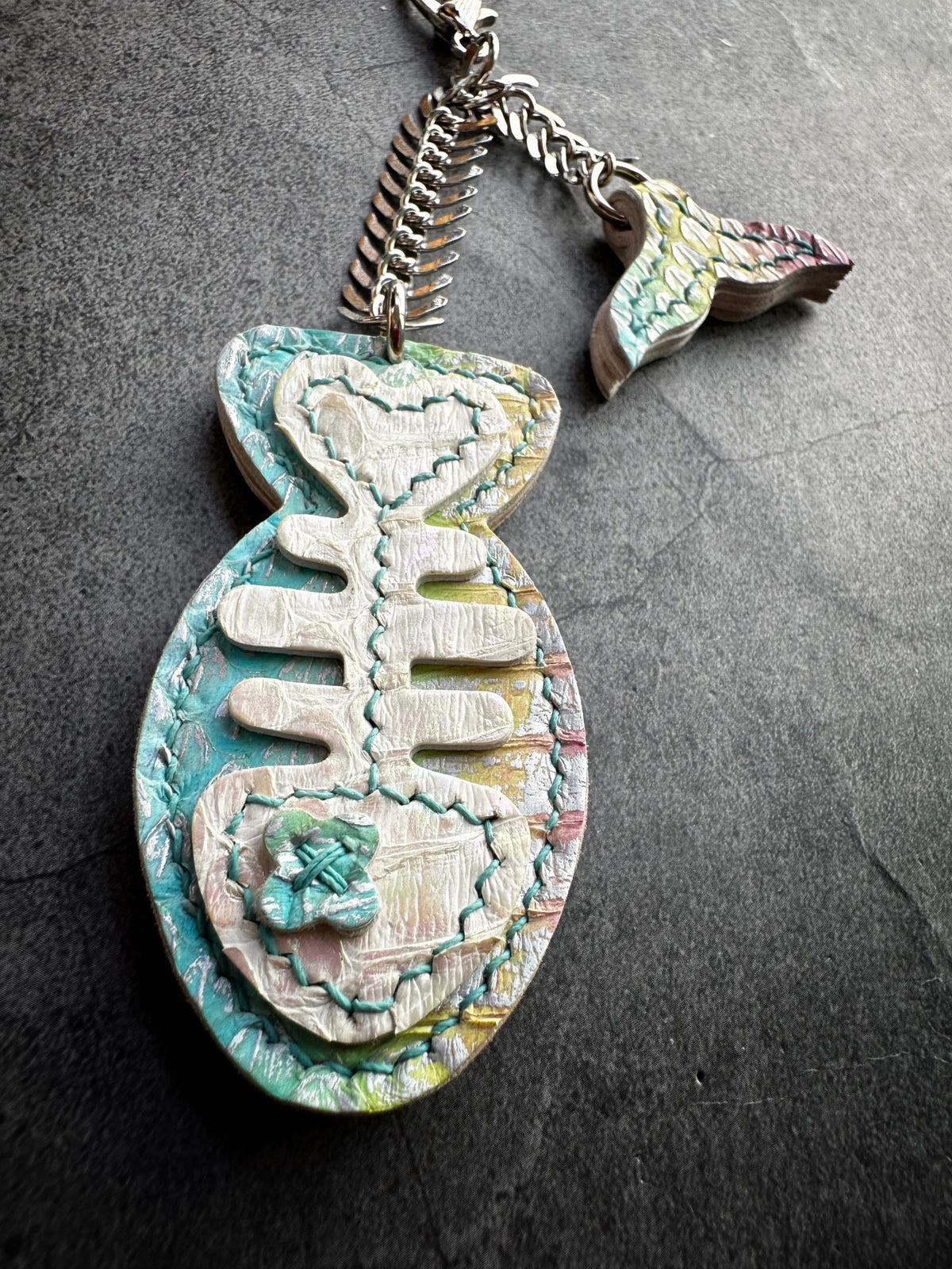 Pendentif os de poisson en cuir irisé
