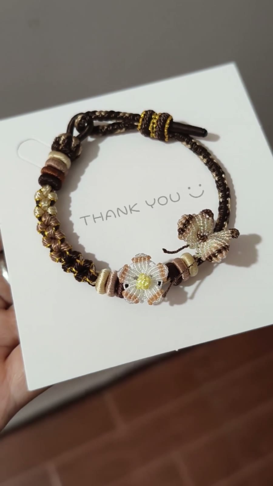 Handflätat armband i snöre svart guld blomma