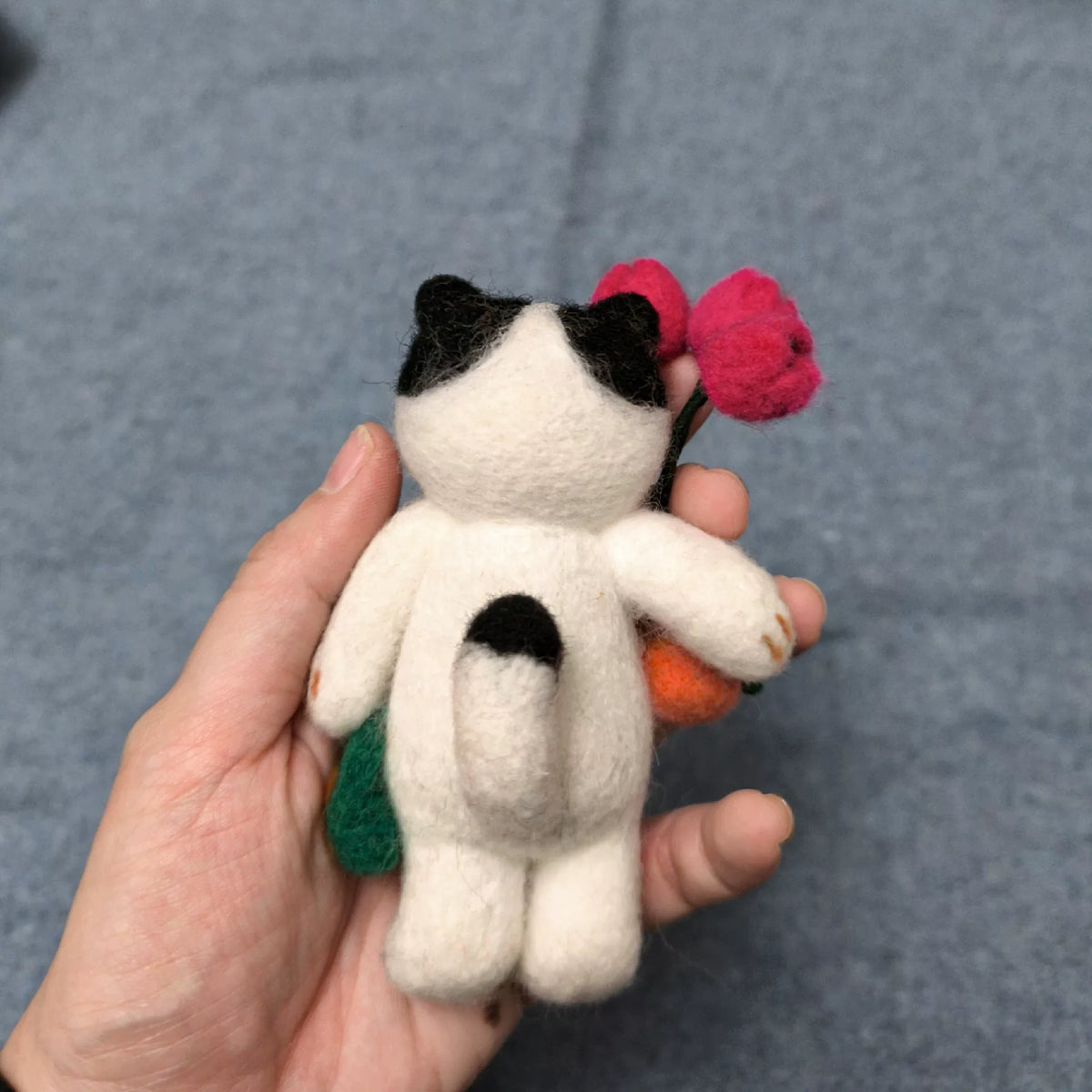 Handgemaakte vilten kattenfiguur van wol met tulpen
