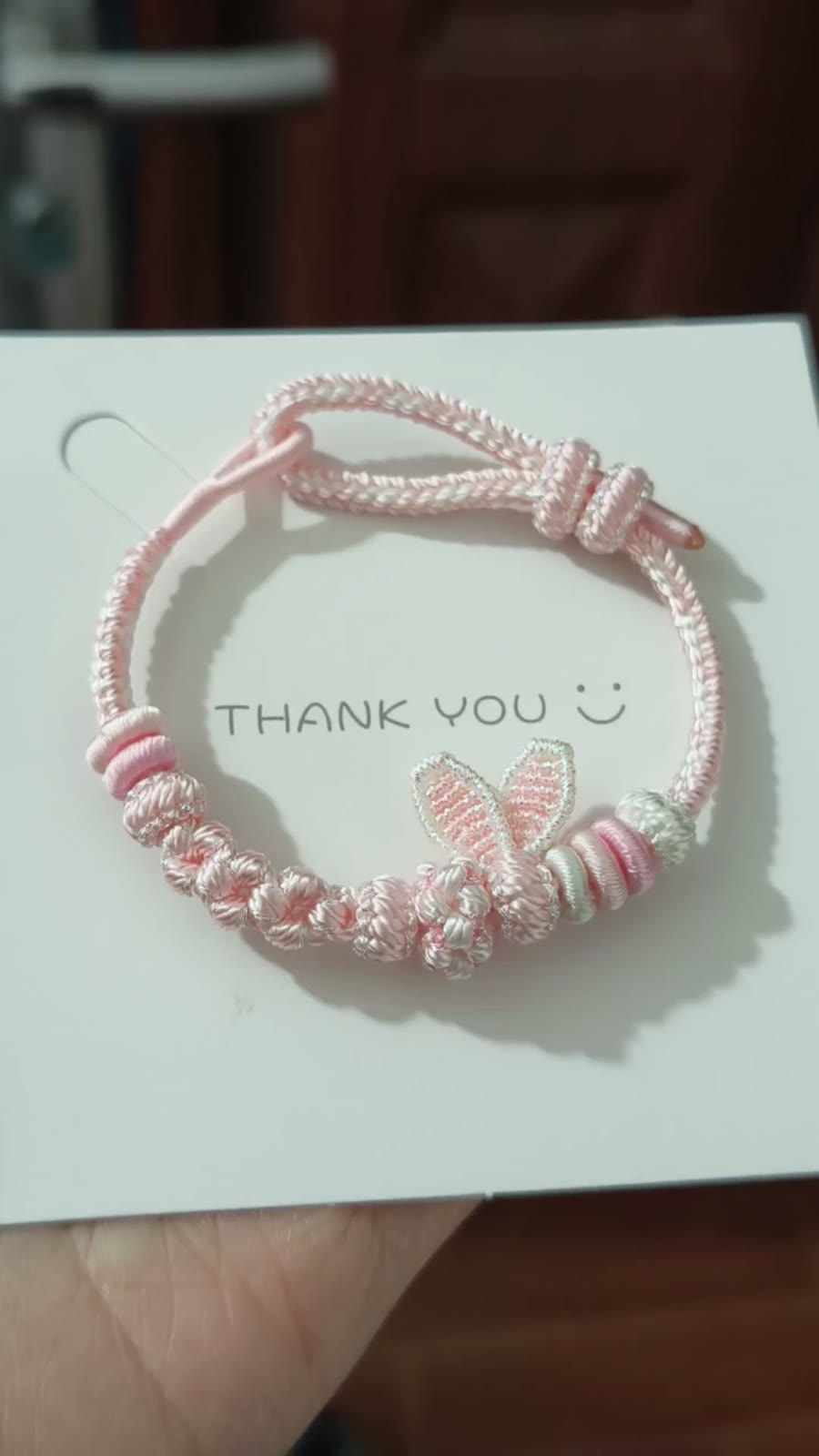 Handgema roze gevlochten armband met konijnenostjes