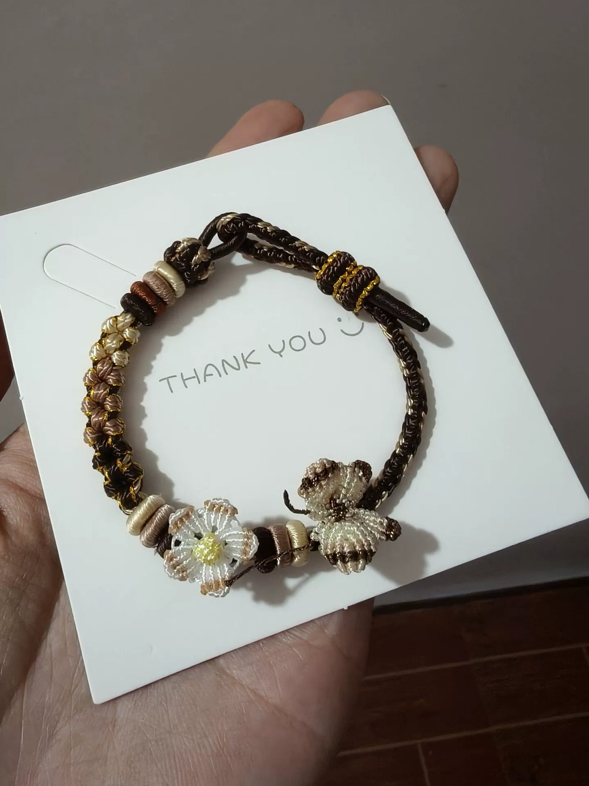 Handflätat armband i snöre svart guld blomma