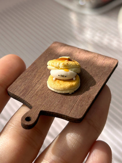 Miniature Pancake Stack with Seal Figurine on Wooden Board