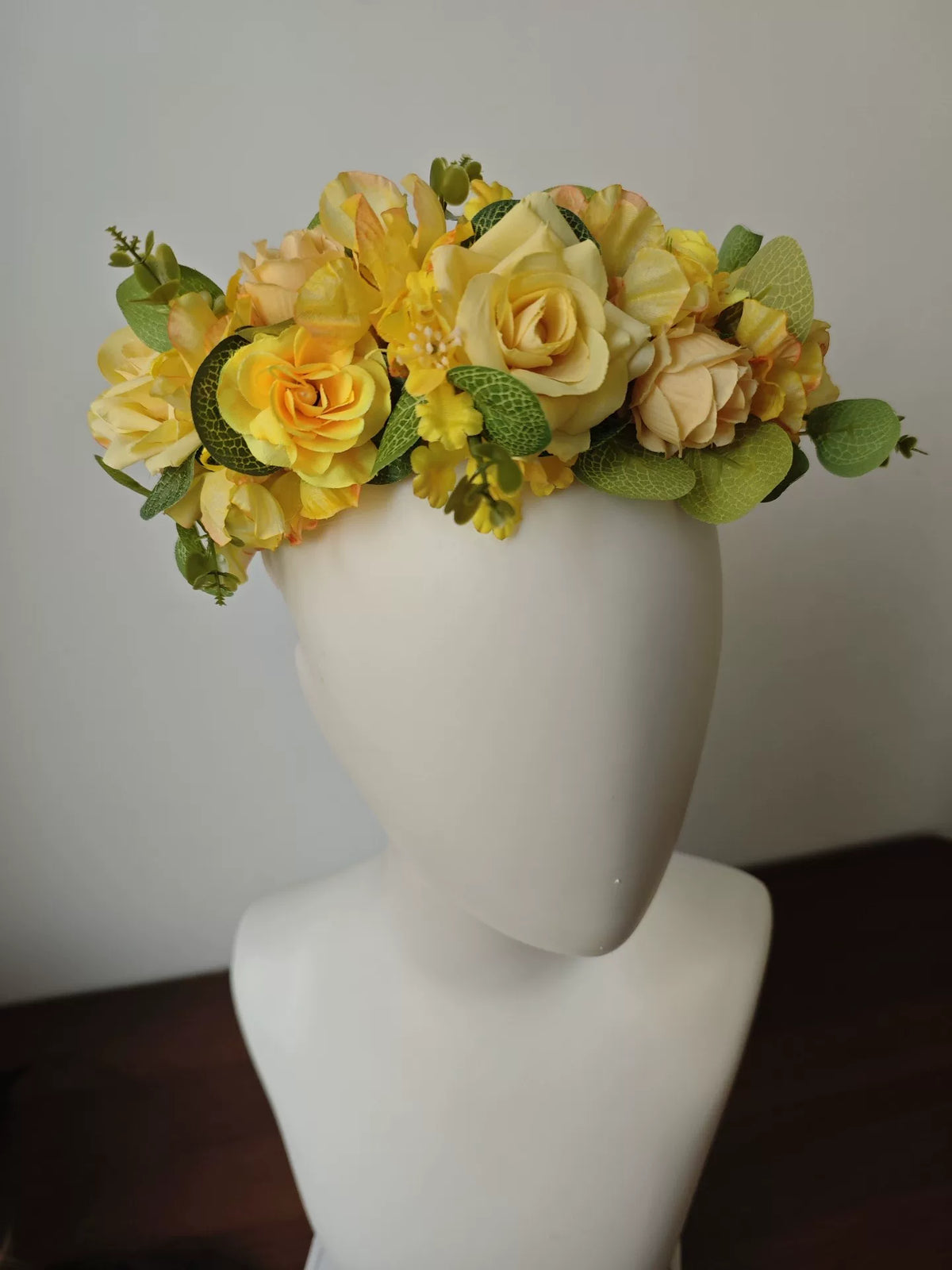 Blomsterkrans med guldgula rosor i skogsdesign