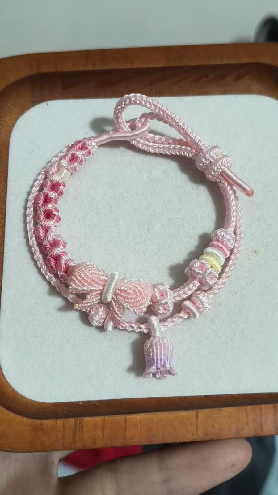 Bracciale in cordino intrecciato con sfumatura rosa e fiori