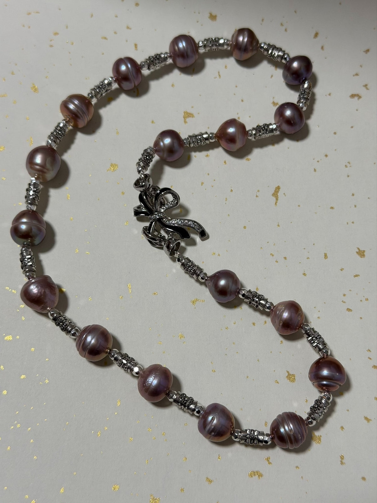 Collier de perles mauve avec fermoir en nœud