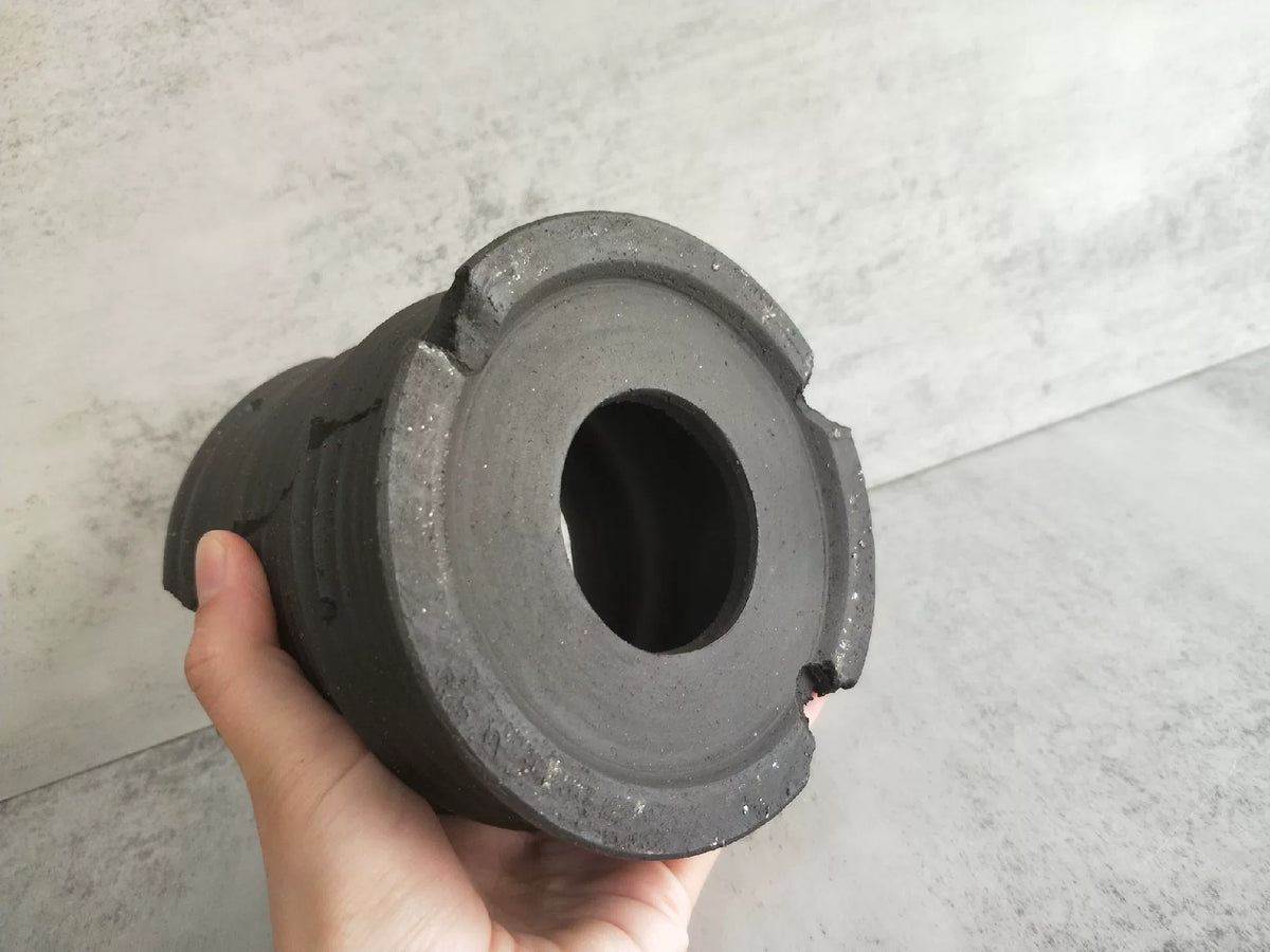 Ongeglazuurd zwart keramisch vat met ribbelstructuur