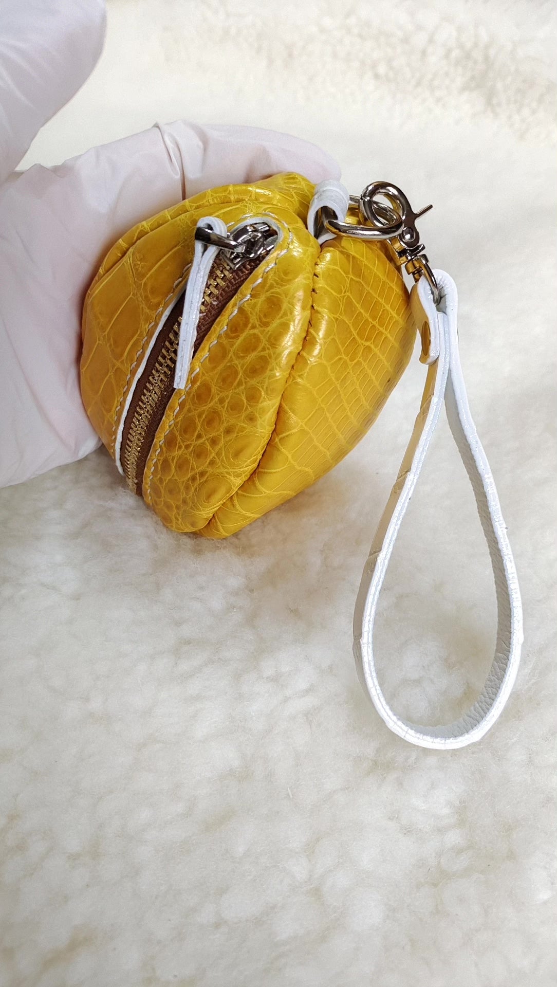 Pouch i guldene krokodilläder formad som en fotboll