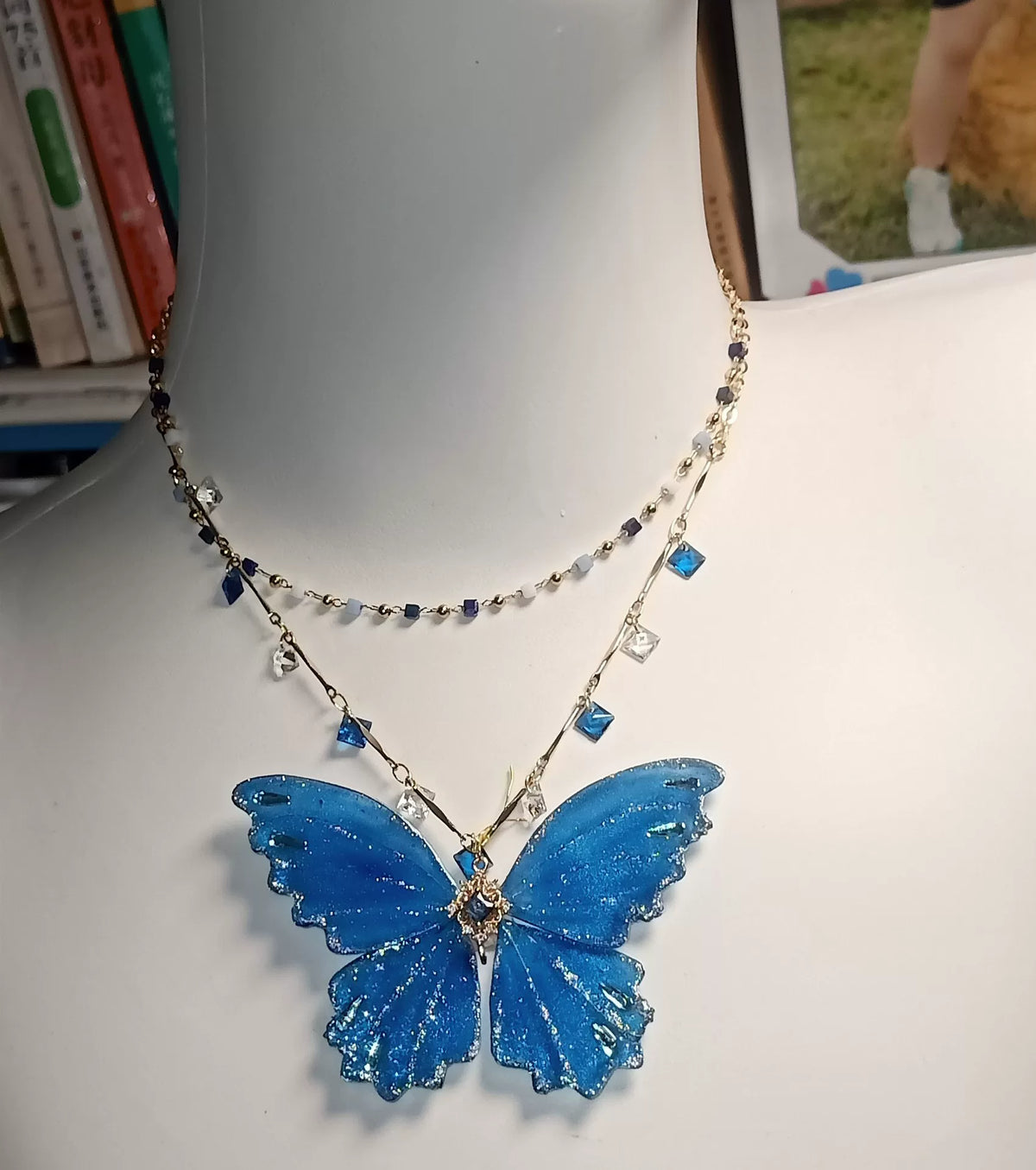 Collar de mariposa en laca azul y purpurina