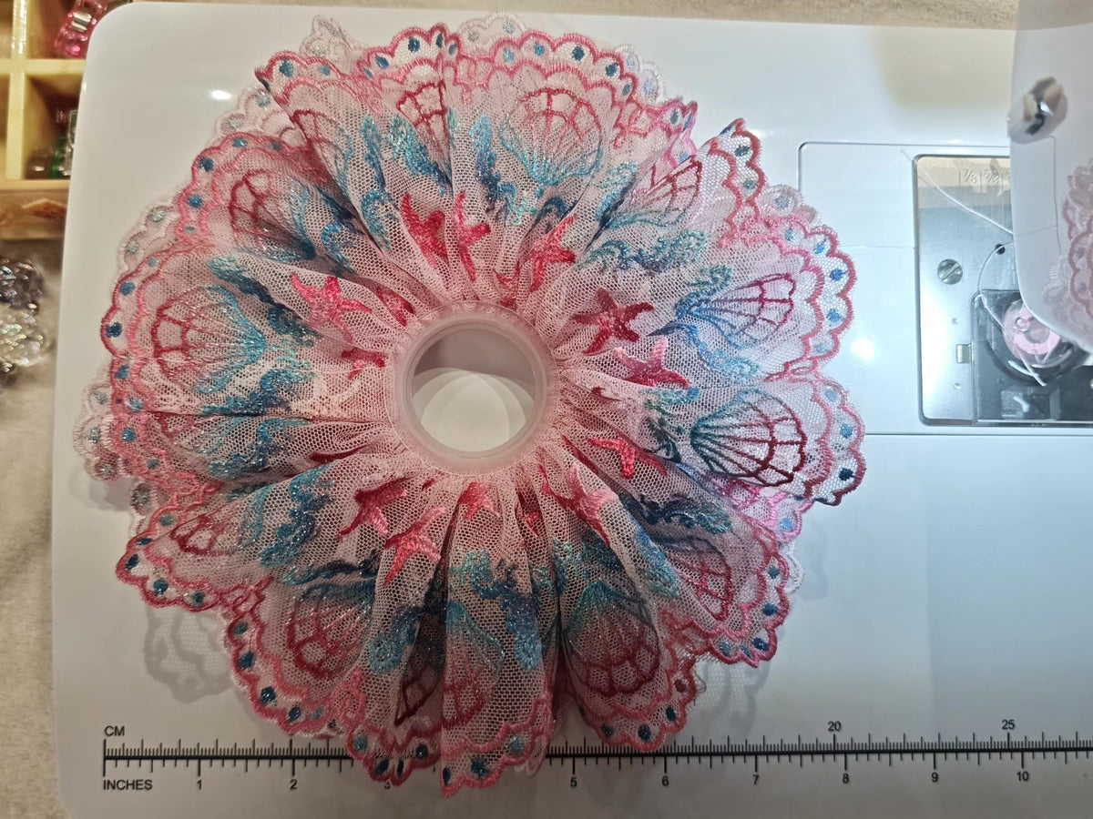 Scrunchie in pizzo rosa con ricamo di conchiglie e stelle marine