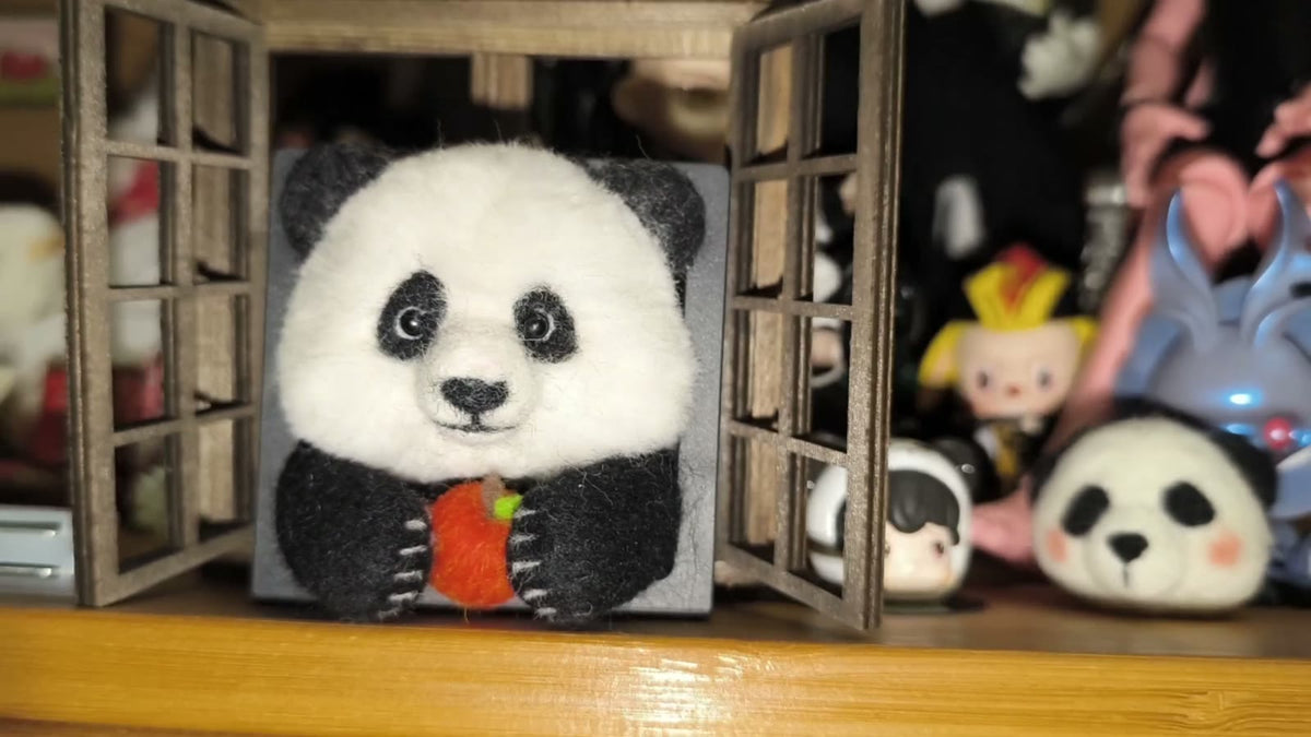 Handgjord ramdekor med panda i ullfilt som äter äpple