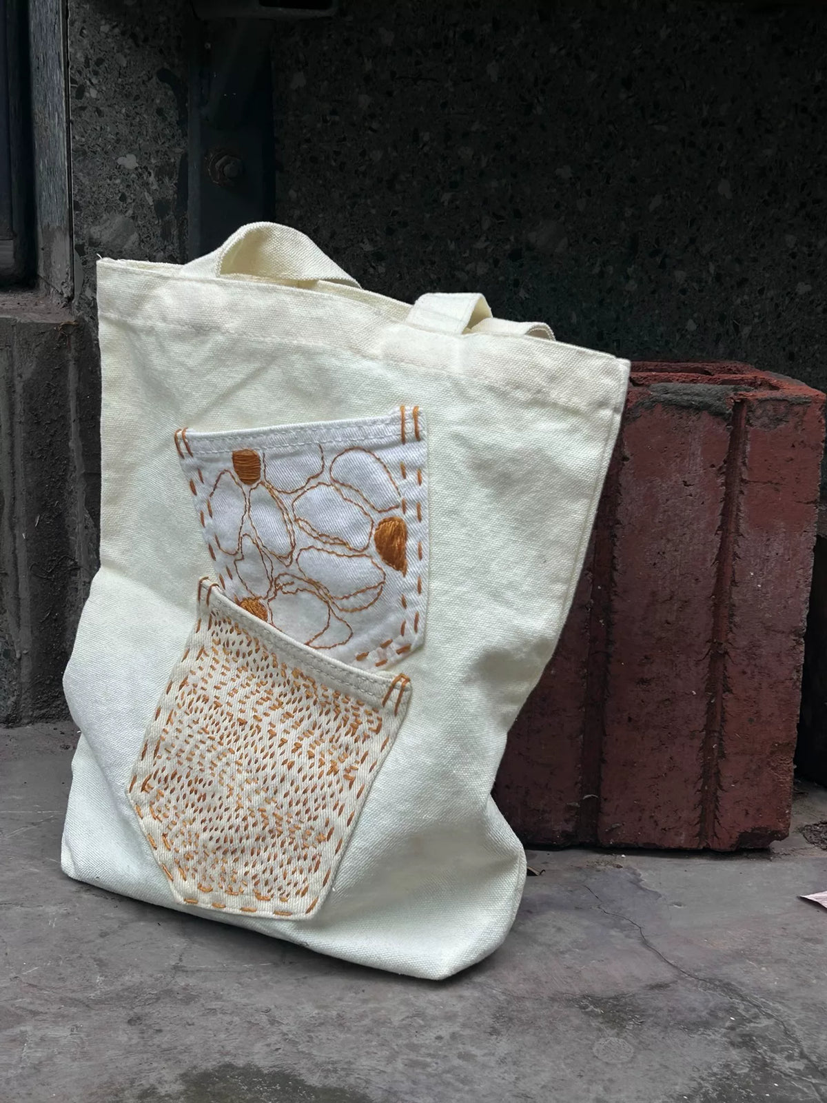 Bolso de hombro de tejido marfil con bolsillos bordados