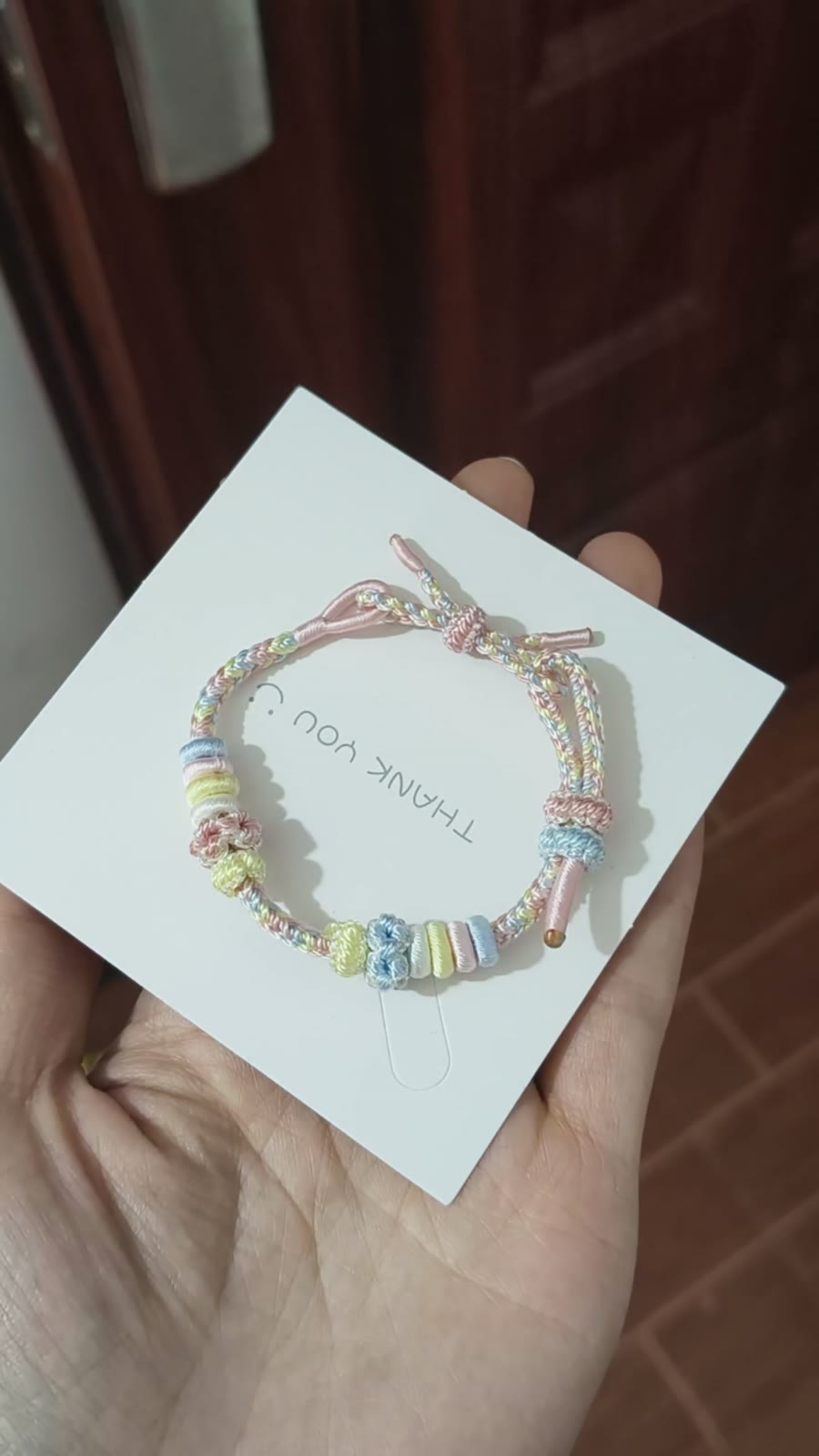 Braccialetto intrecciato arcobaleno con nodi a fiore