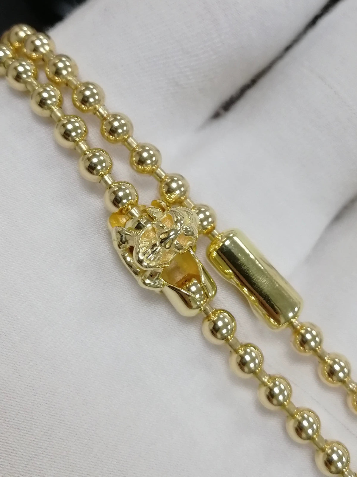 Chaîne de perles dorées avec fermoir crâne