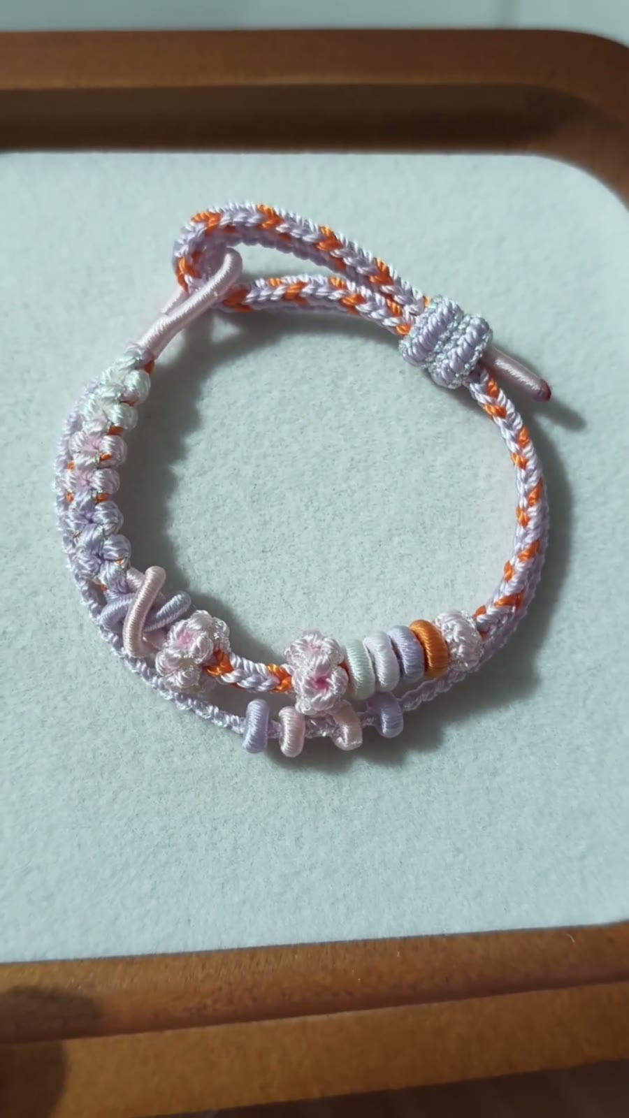 Handvävt armband i snöre vit och orange blomma