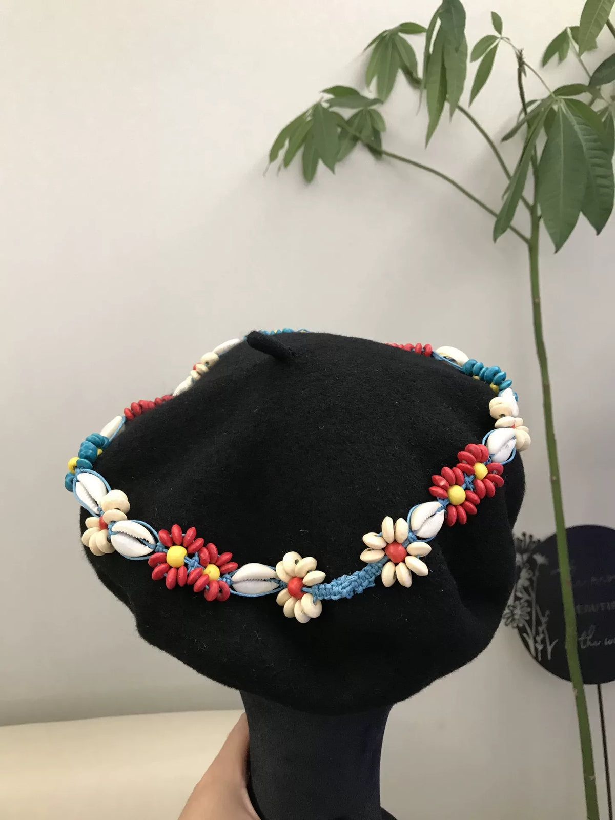 Berretto nero con fascia floreale di perline