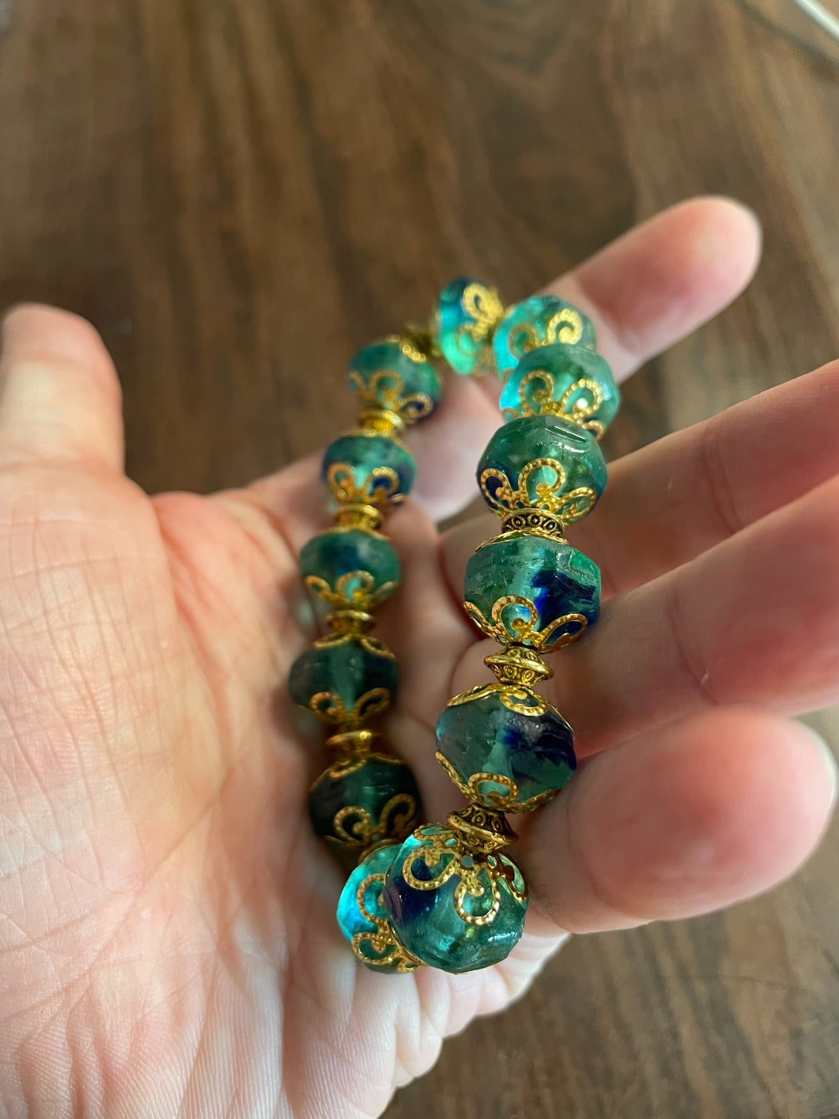 Groene glazen kralenarmband met blauwe wirlels