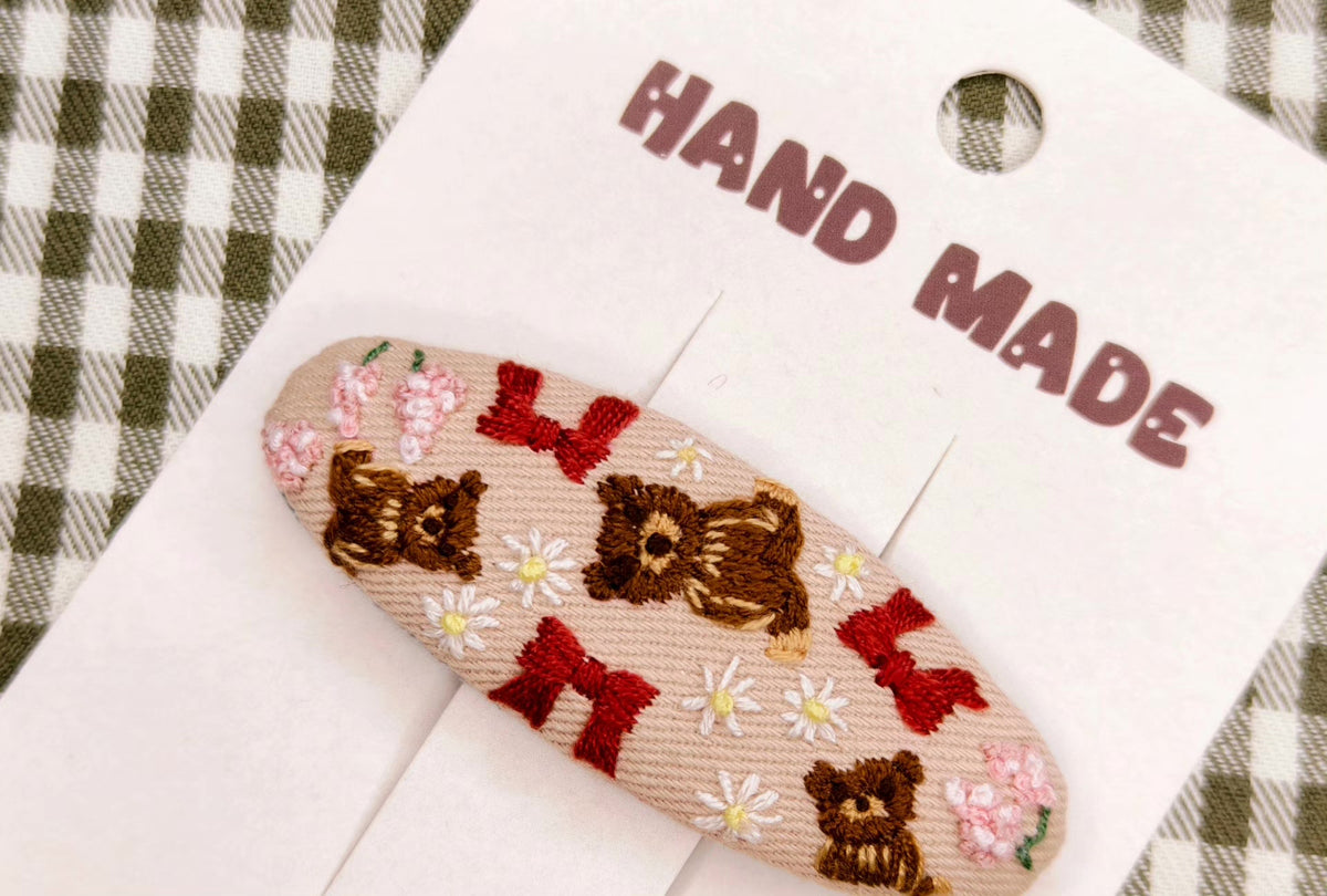 Handbroderat hårspänne med bruna björnar