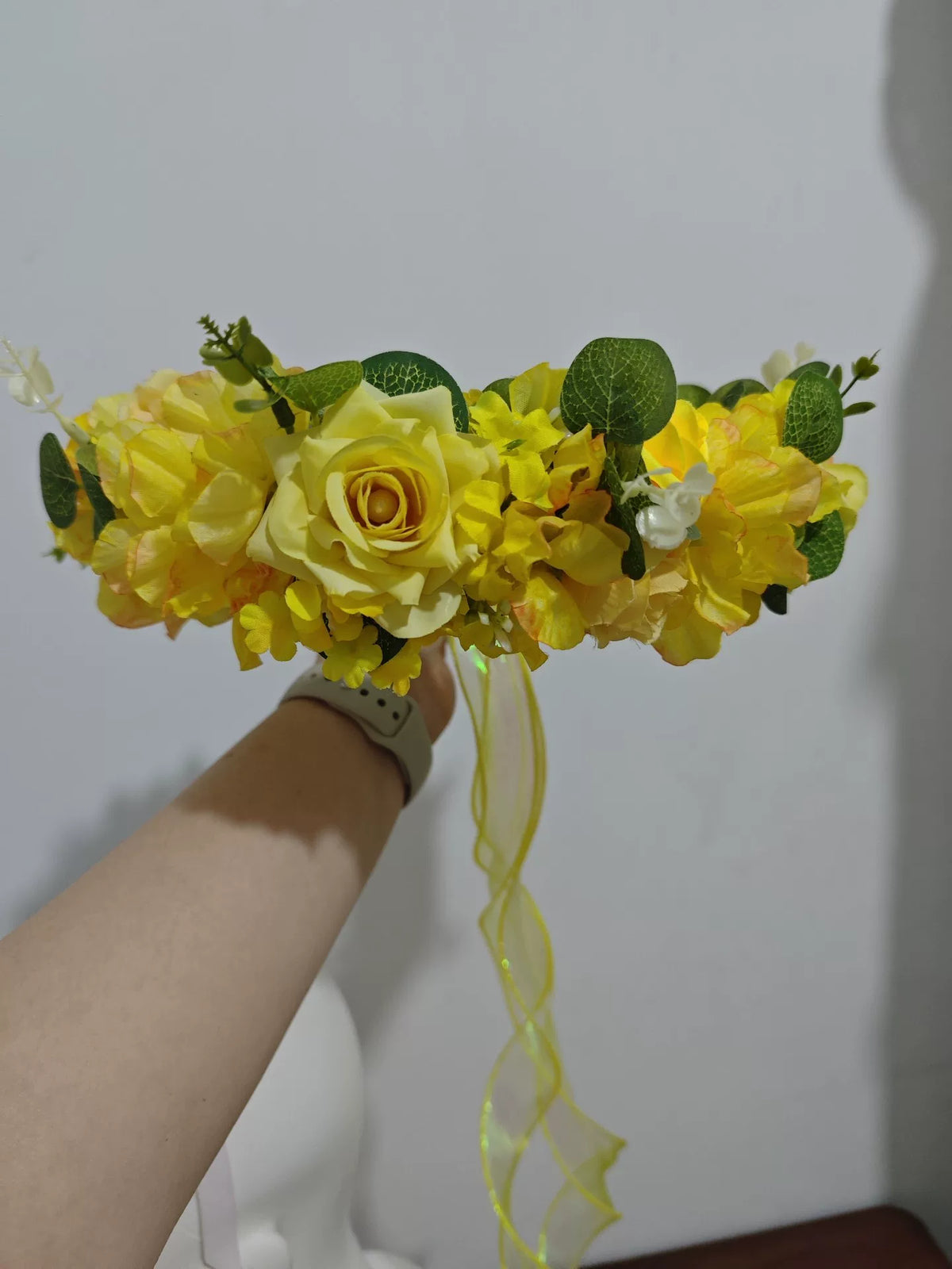 Blomsterkrans med guldgula rosor i skogsdesign