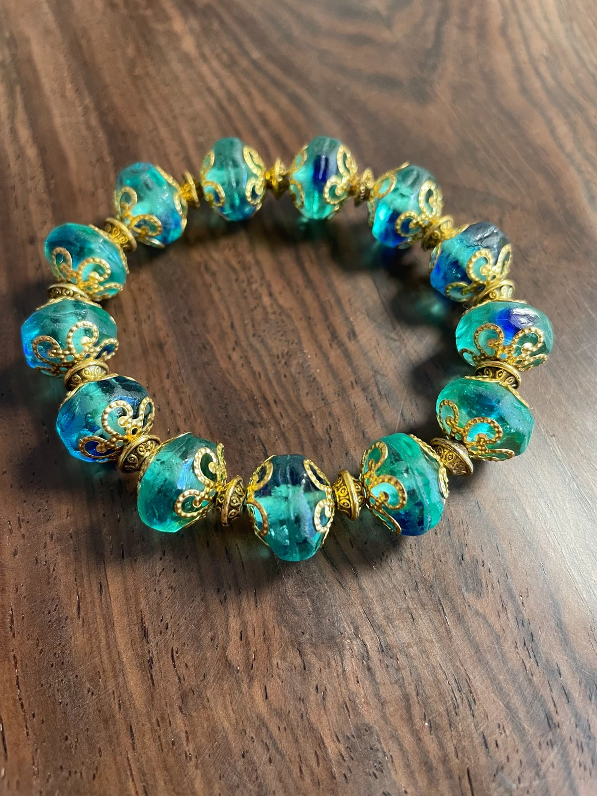 Groene glazen kralenarmband met blauwe wirlels