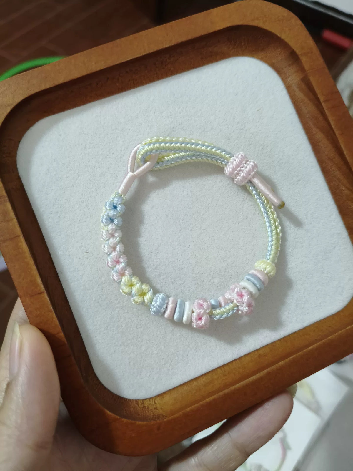 Pulsera de cordón trenzado a mano con flores en degradado pastel