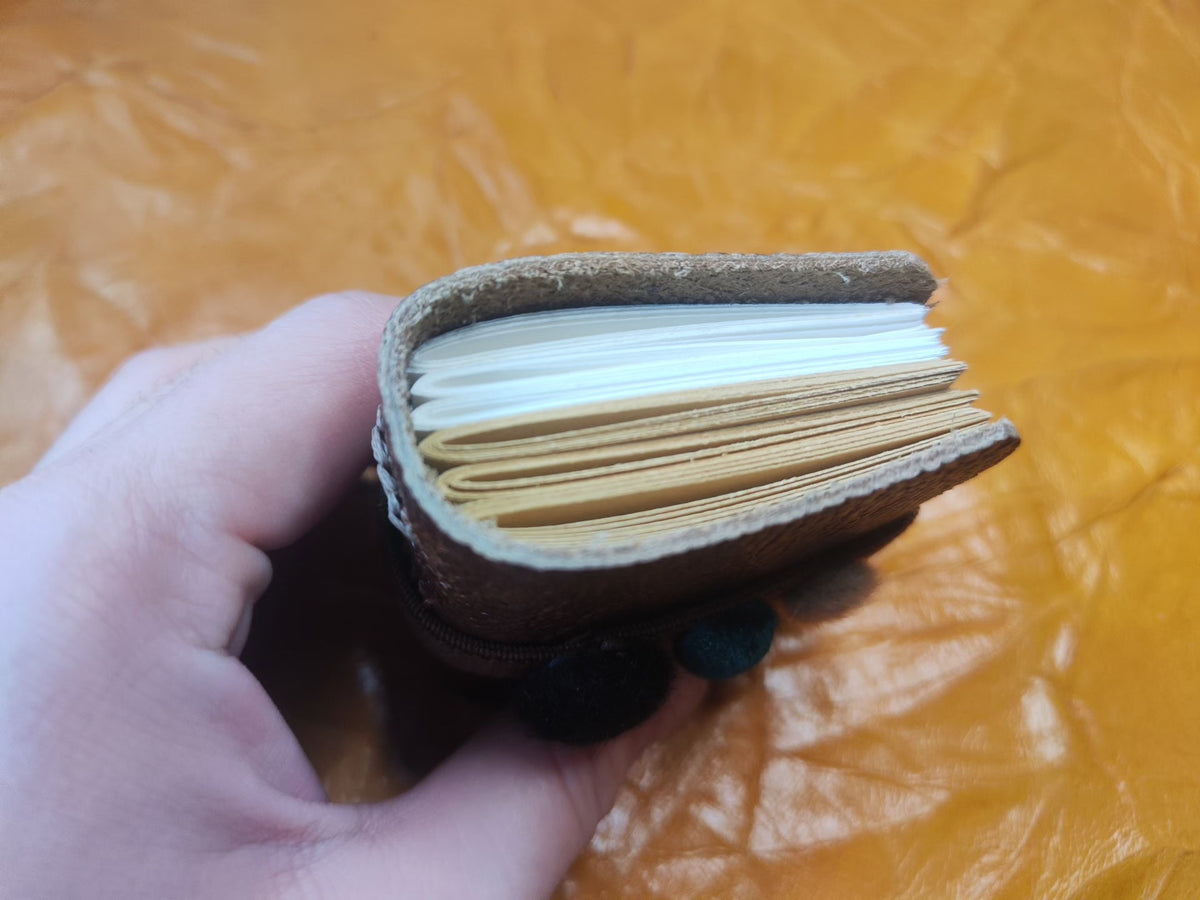Mini carnet en cuir avec bande à pompons