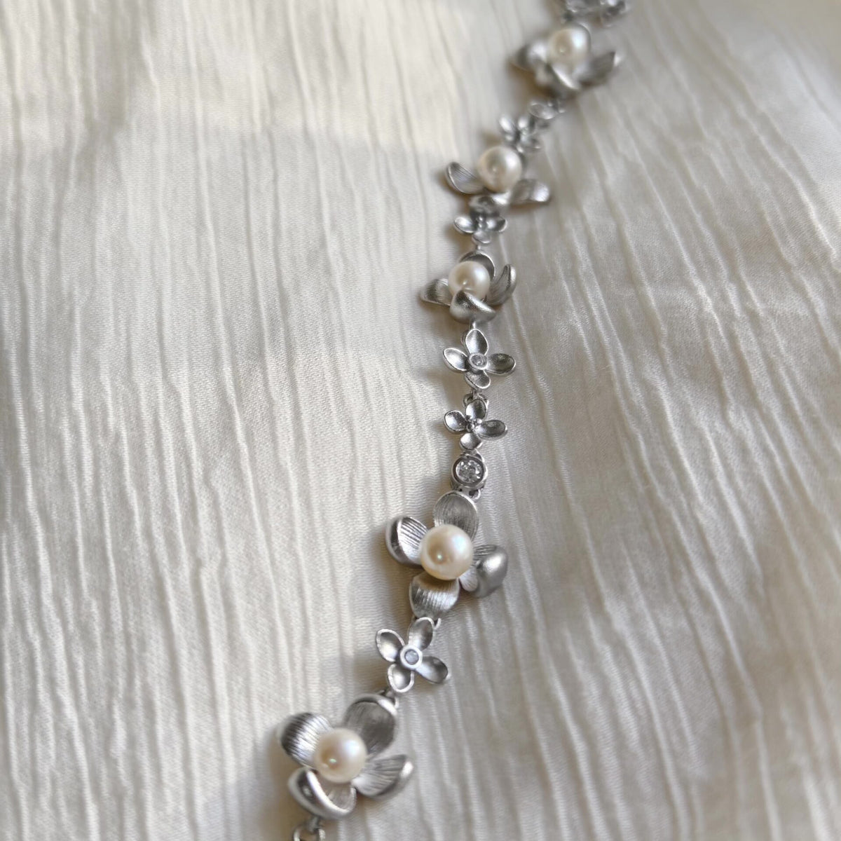 Braccialiale floreale in argento spazzolato con perle naturali