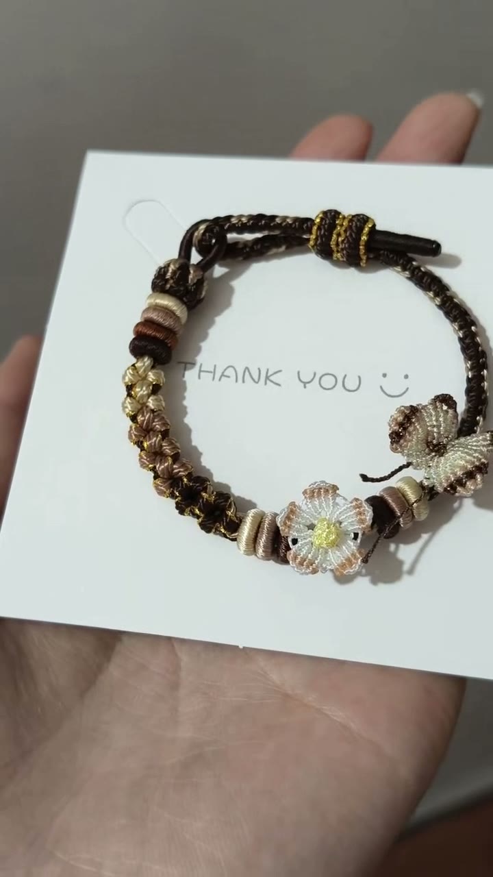 Handgjort flätat armband i brun snodd med blomberlock