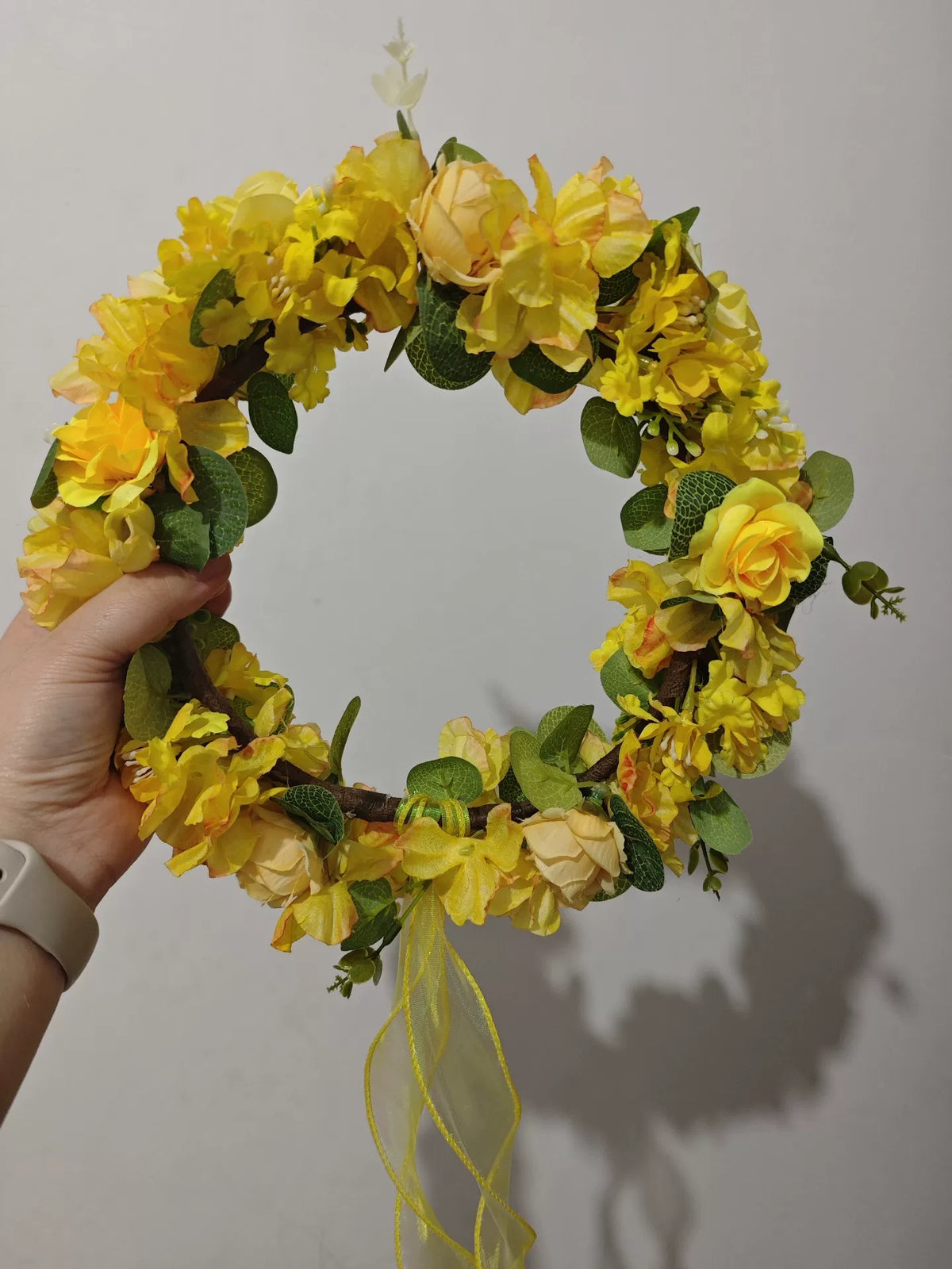 Blomsterkrans med guldgula rosor i skogsdesign