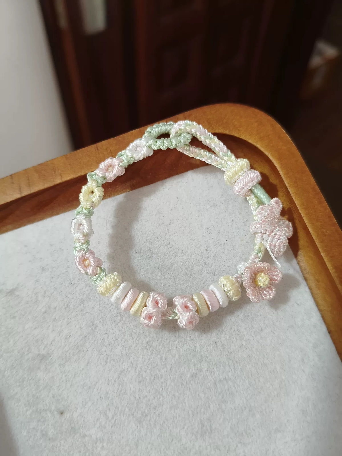 Bracelet en cordon tressé fleurs pastel et papillon