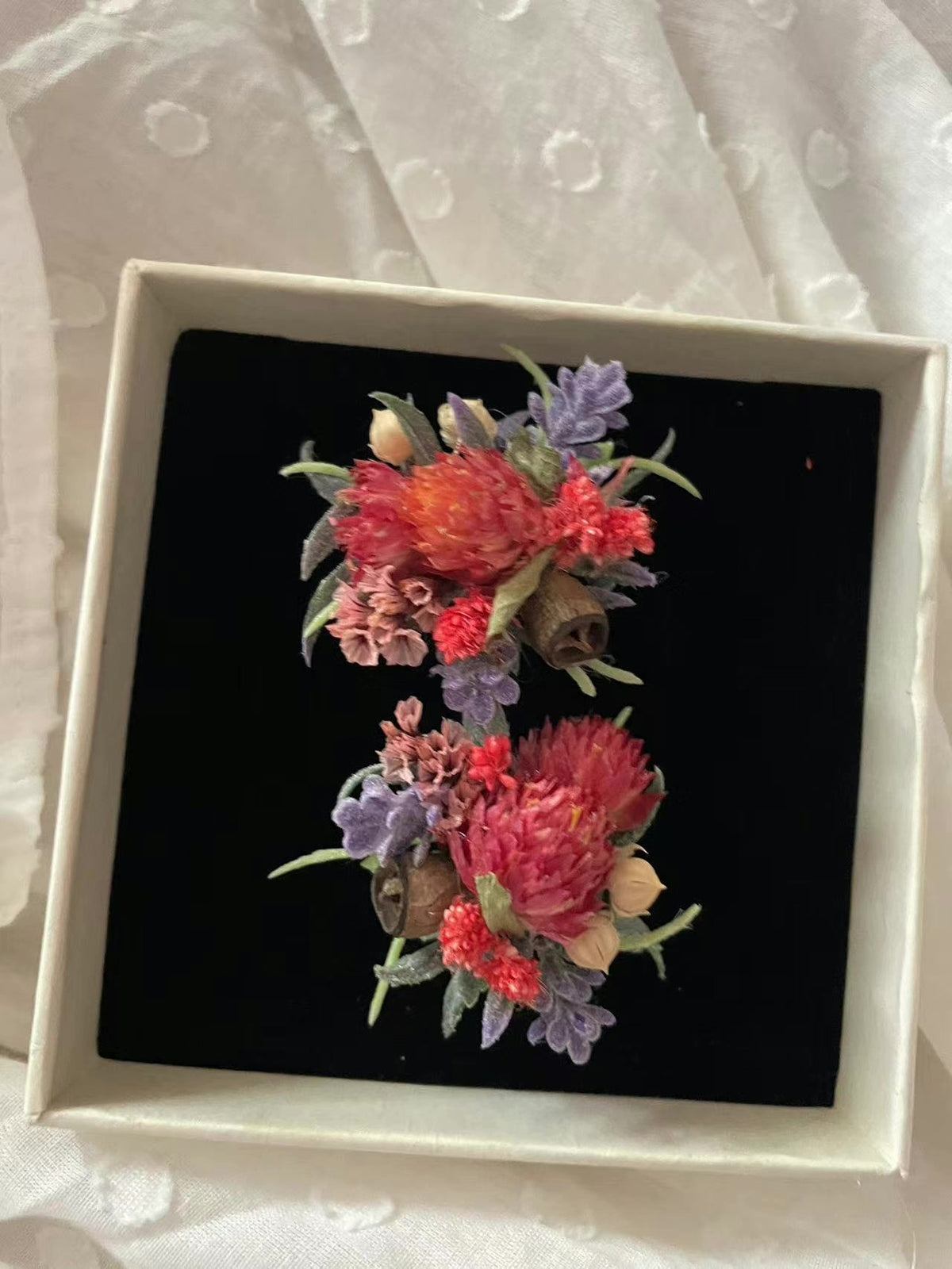 Coppia di anelli con fiori rossi conservati e scatola bianca