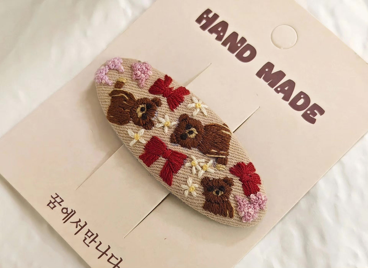 Handbroderat hårspänne med bruna björnar