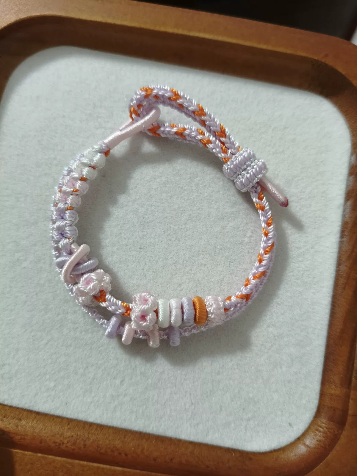 Handvävt armband i snöre vit och orange blomma