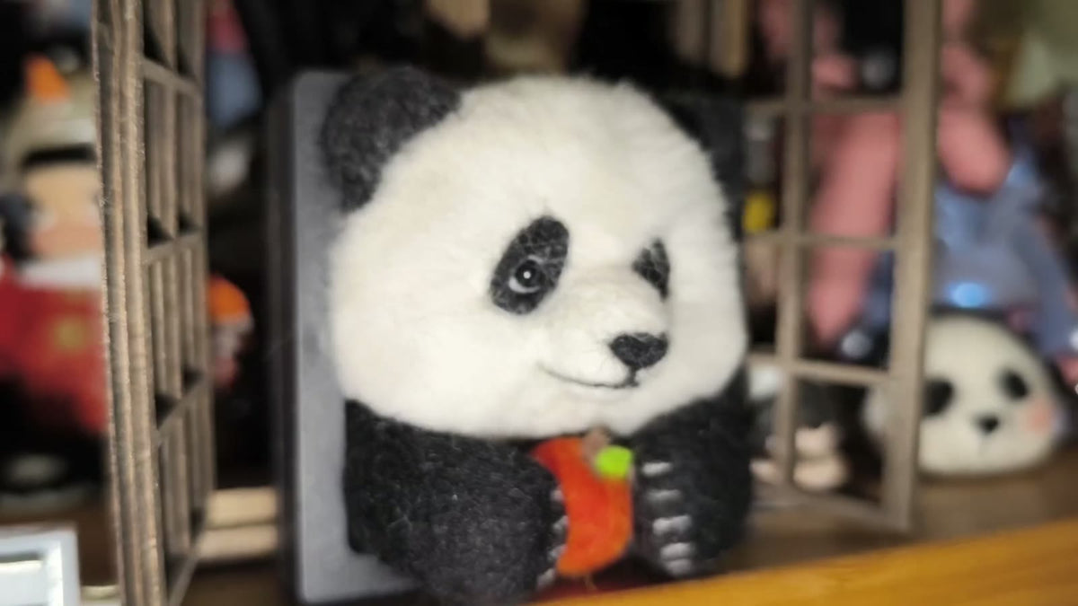 Handgjord ramdekor med panda i ullfilt som äter äpple