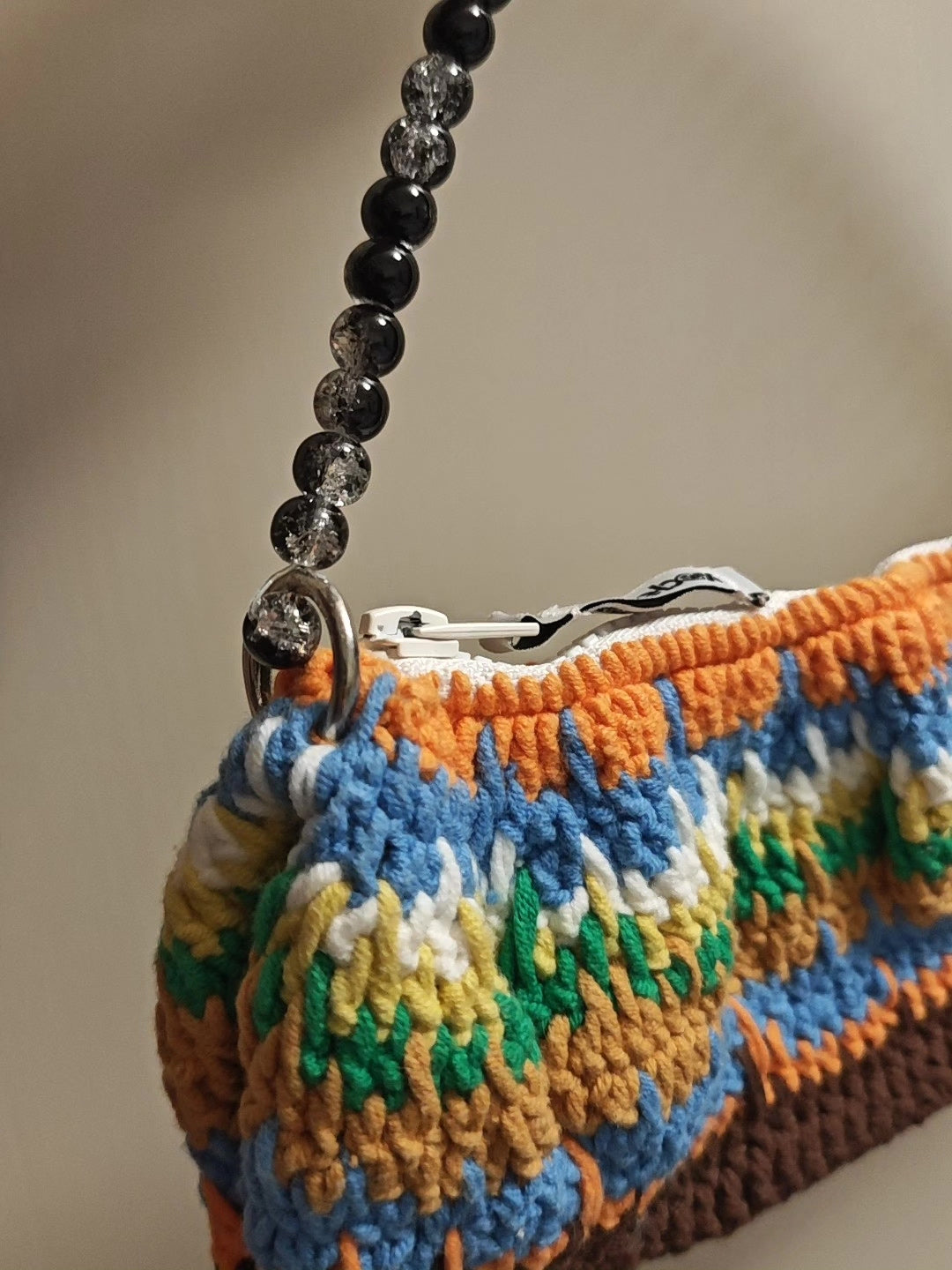 Mehrfarbige handgefertigte Häkeltasche mit Perlenriemen