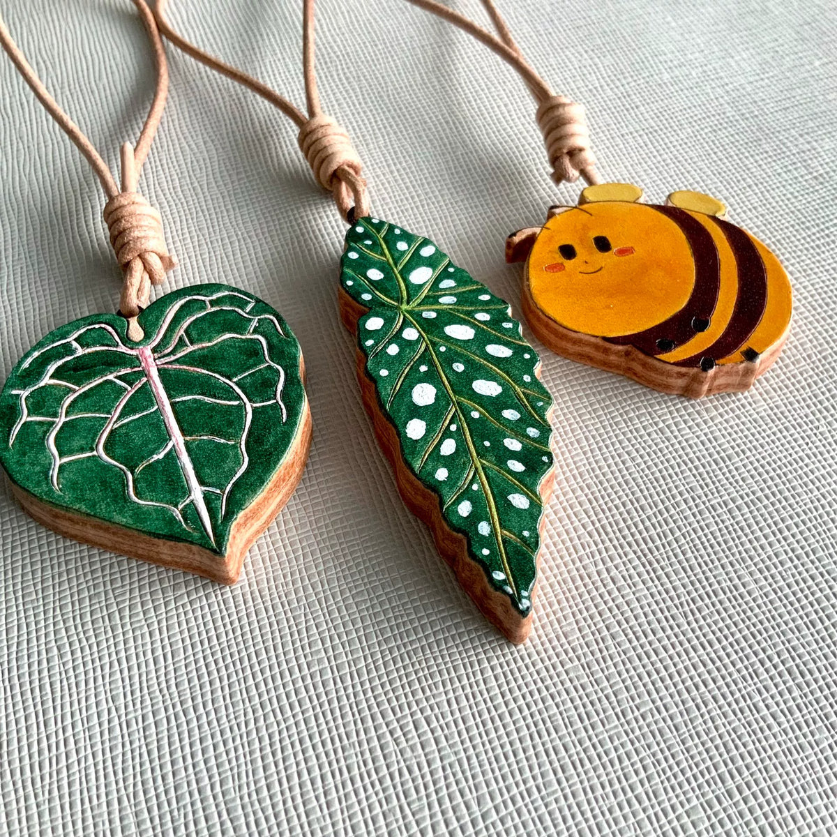 Handbeschilderde Leren Blad en Bij Charms