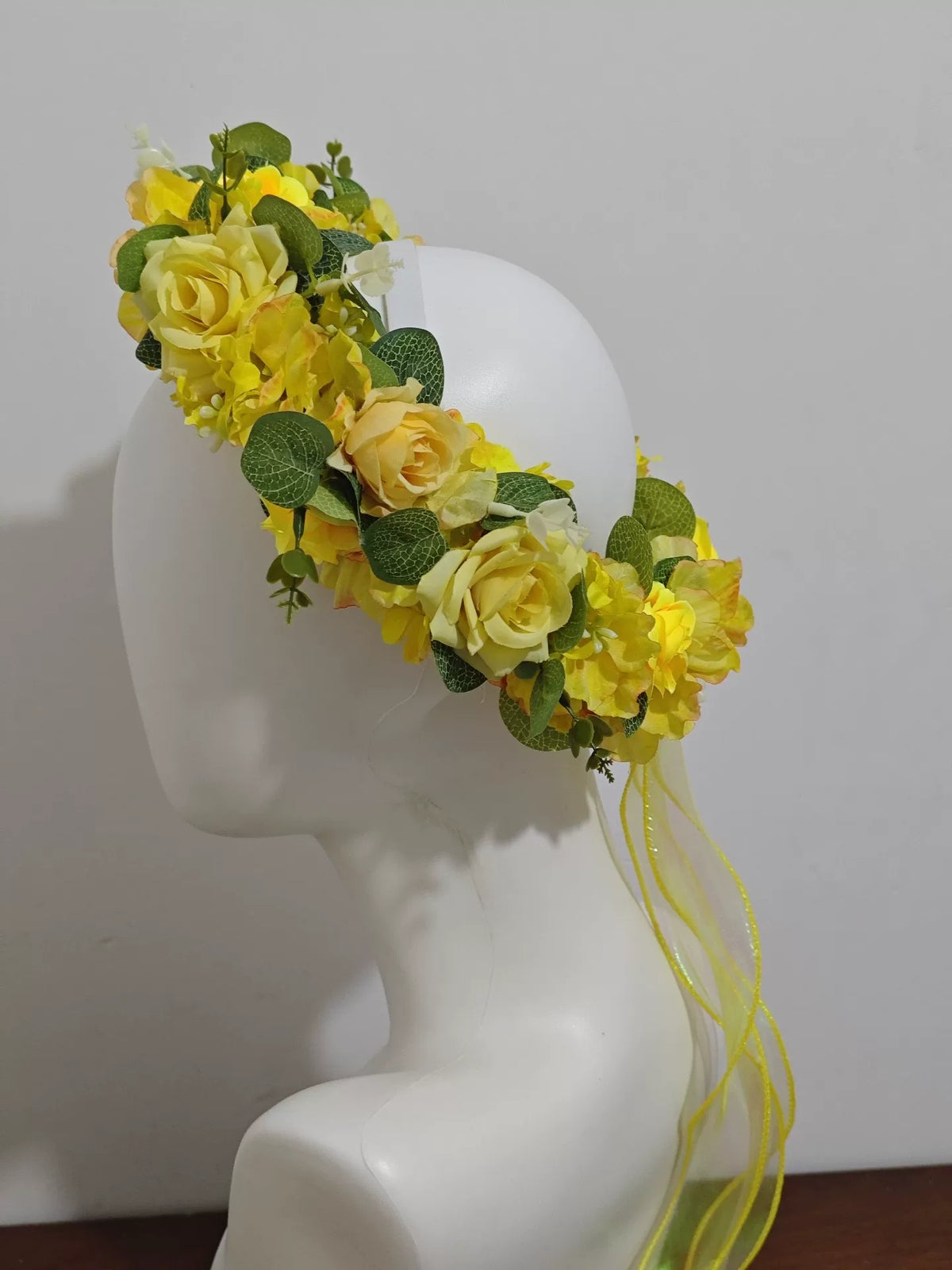 Blomsterkrans med guldgula rosor i skogsdesign
