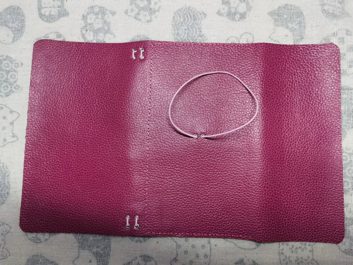 Bokomslag i rosrosa läder med trefaldig vikning