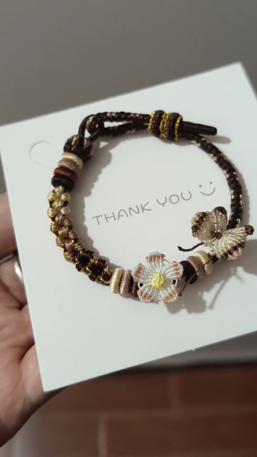 Handflätat armband i snöre svart guld blomma