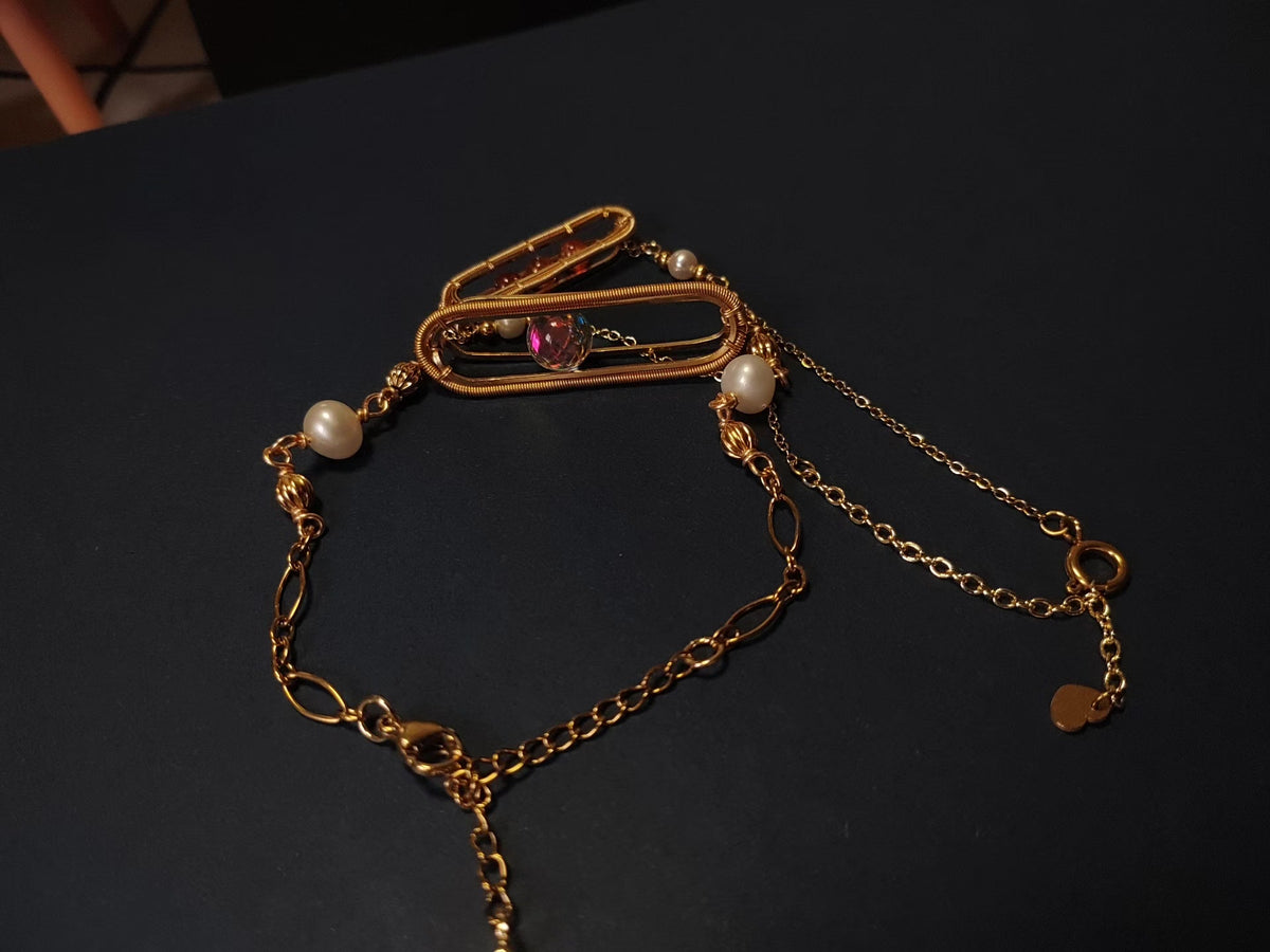 Goudenen armband met zandloper draadwerk en parels