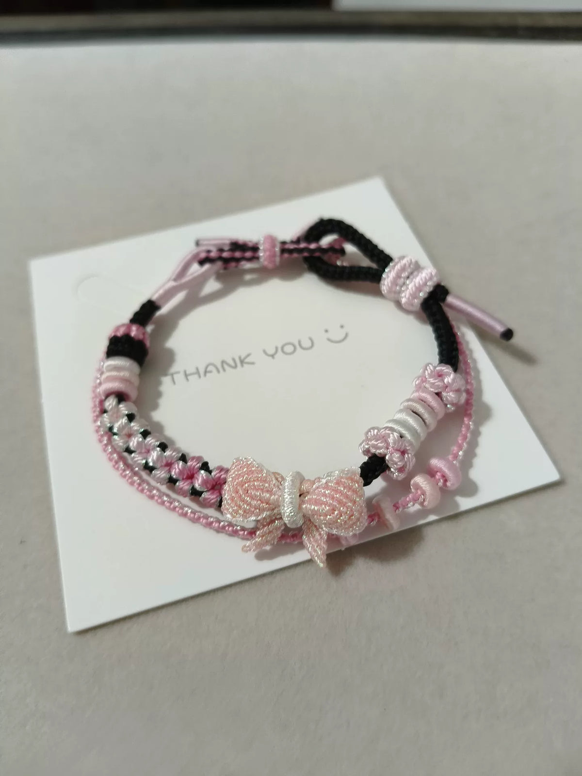 Handgewoven zwart-roze armband met stri