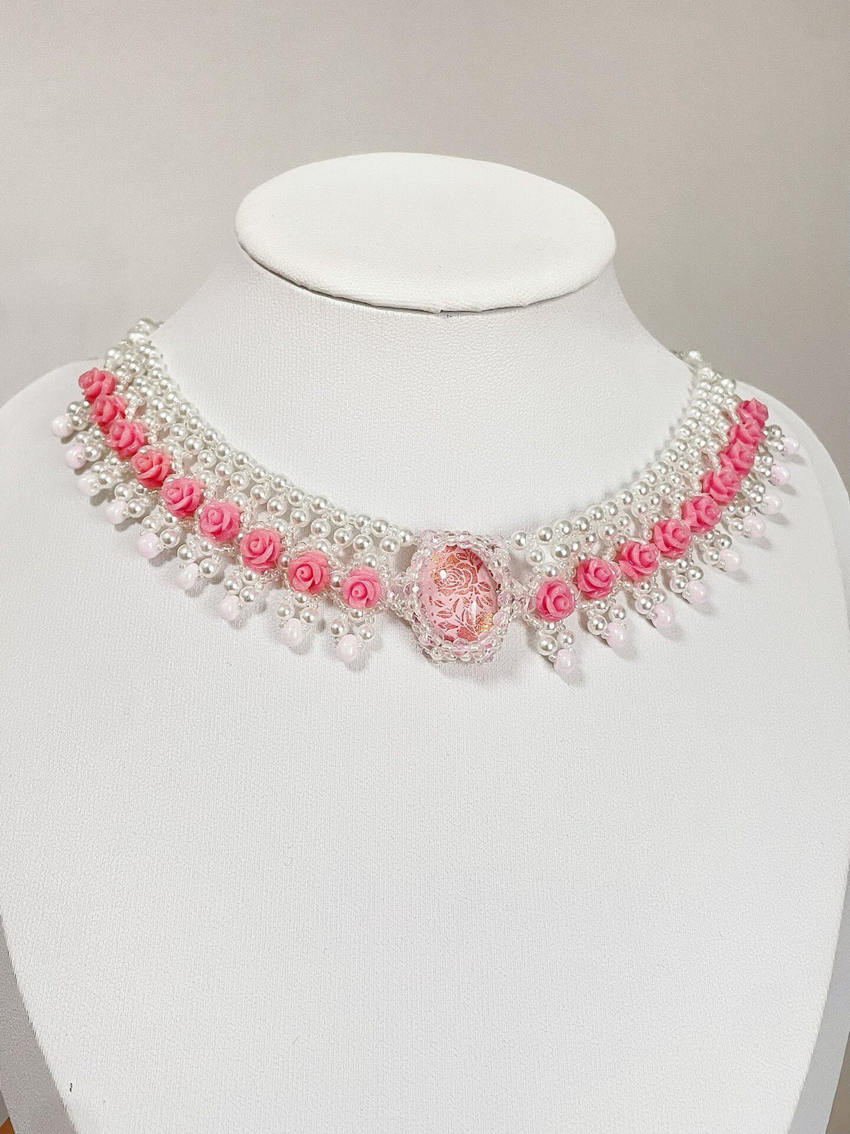 Roze kralenketting met rozenbloemen
