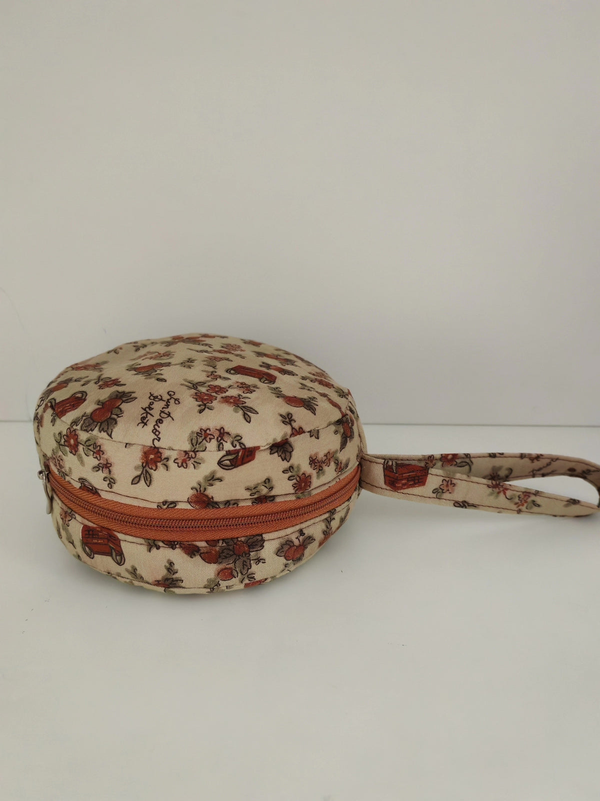 Estuche redondo floral con correa de muñeca