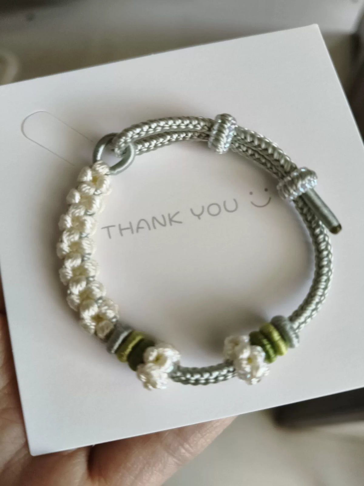 Pulsera de cordón trenzada a mano con flores verdes y blancas